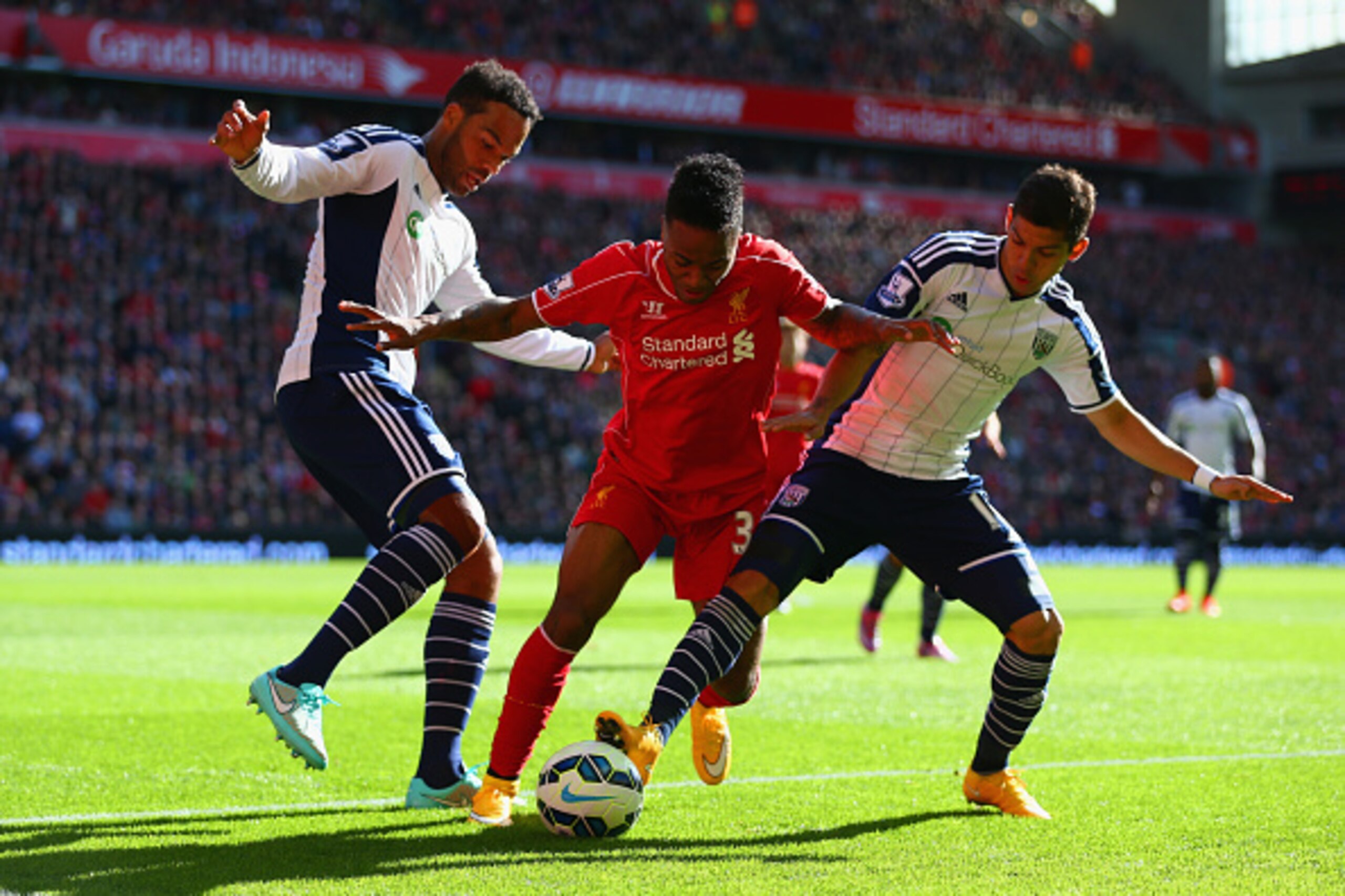 LIVERPOOL, ENGLAND - OCTOBER 04:  Raheem Sterling of Liverpool is closed down by Joleon Lescott and Cristian Gamboa of West Brom during the Barclays Premier League match between Liverpool and West Bromwich Albion at Anfield on October 4, 2014 in Liverpool