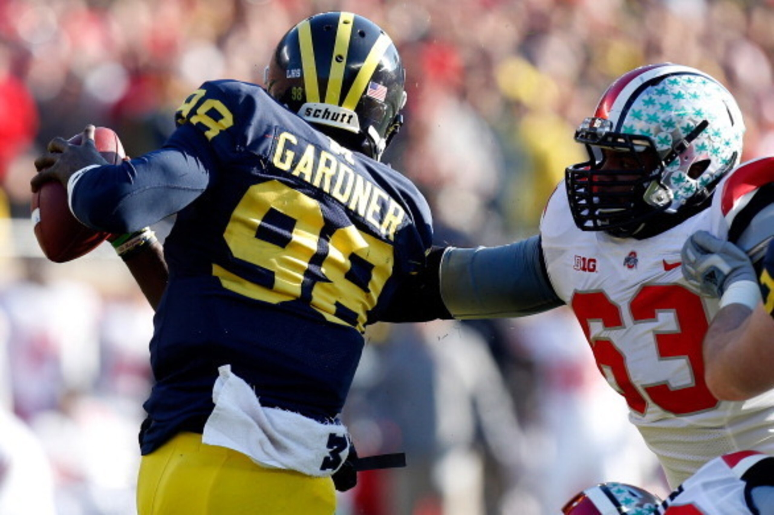 ANN ARBOR, MI - NOVEMBER 30:  Quarterback Devin Gardner #98 of the Michigan Wolverines avoids a third quarter sack by defensive lineman Michael Bennett #63 of the Ohio State Buckeyes during a game at Michigan Stadium on November 30, 2013 in Ann Arbor, Mic