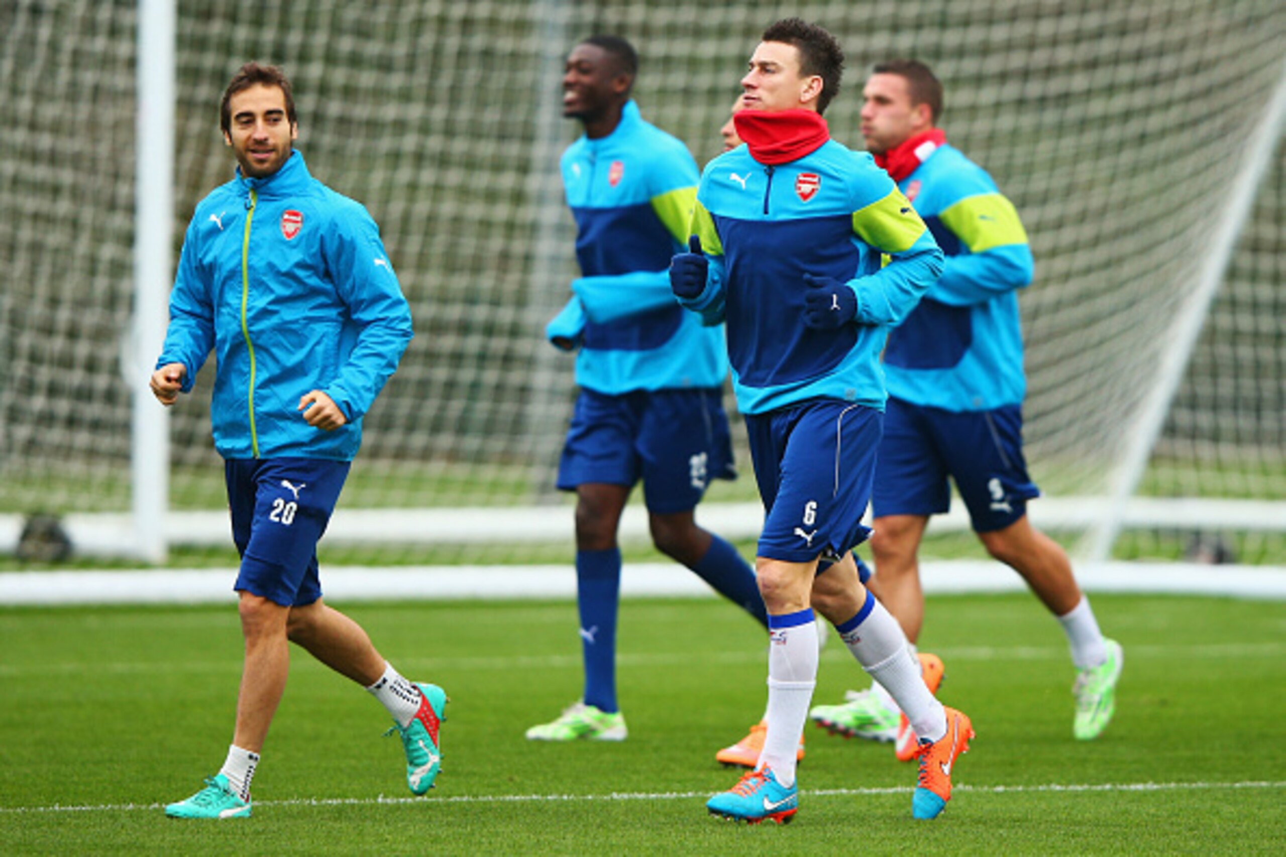 ST ALBANS, ENGLAND - NOVEMBER 25:  Mathieu Flamini (20) and Laurent Koscielny (6) warm up with team mates during an Arsenal training session, ahead of the UEFA Champions League Group D match against Borussia Dortmund, at London Colney on November 25, 2014