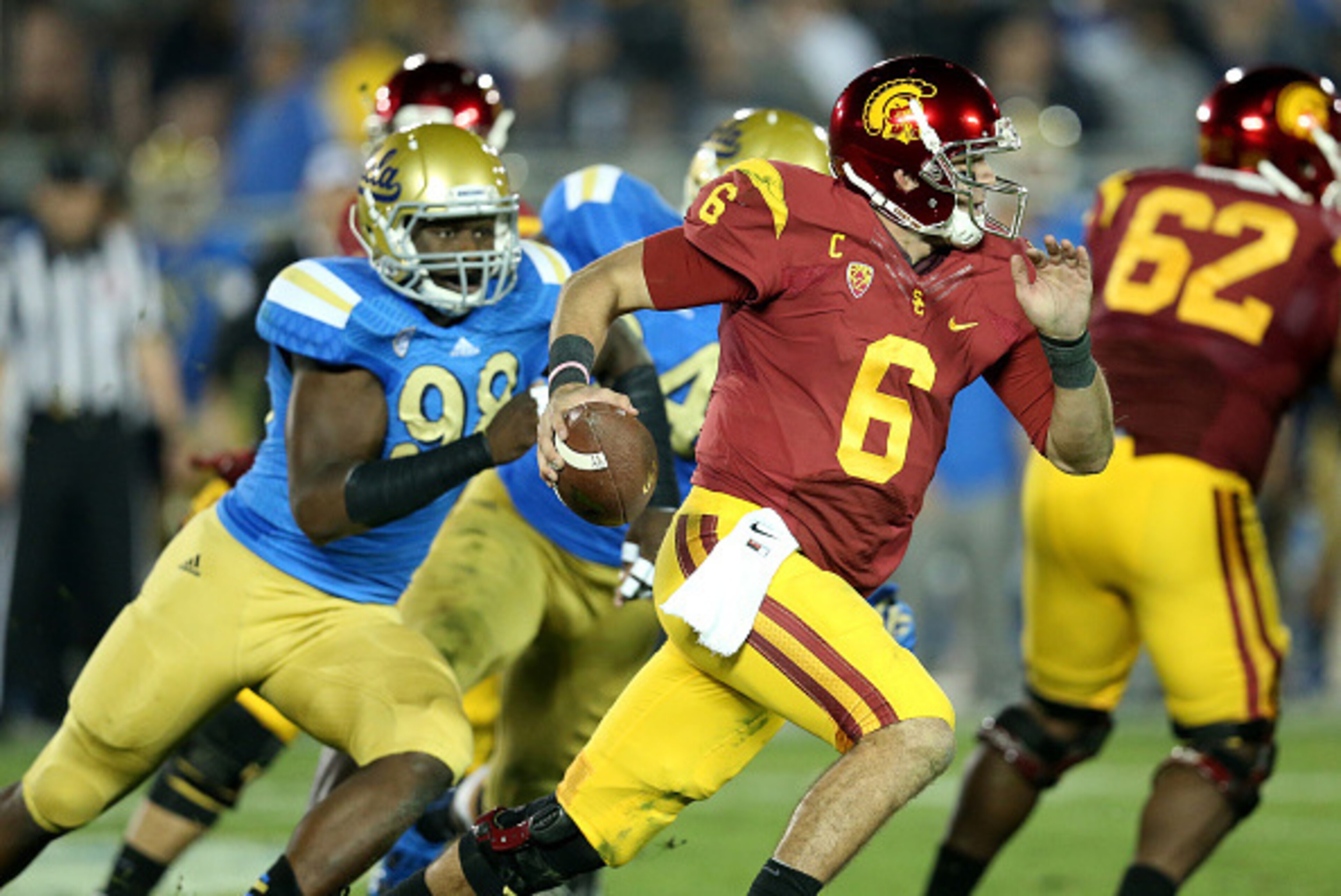 PASADENA, CA - NOVEMBER 22:  Quarterback Cody Kessler #6 of the USC Trojans scrambles away from defensive lineman Takkarist McKinley #98 of the UCLA Bruins in the third quarter at the Rose Bowl on November 22, 2014 in Pasadena, California.  (Photo by Step