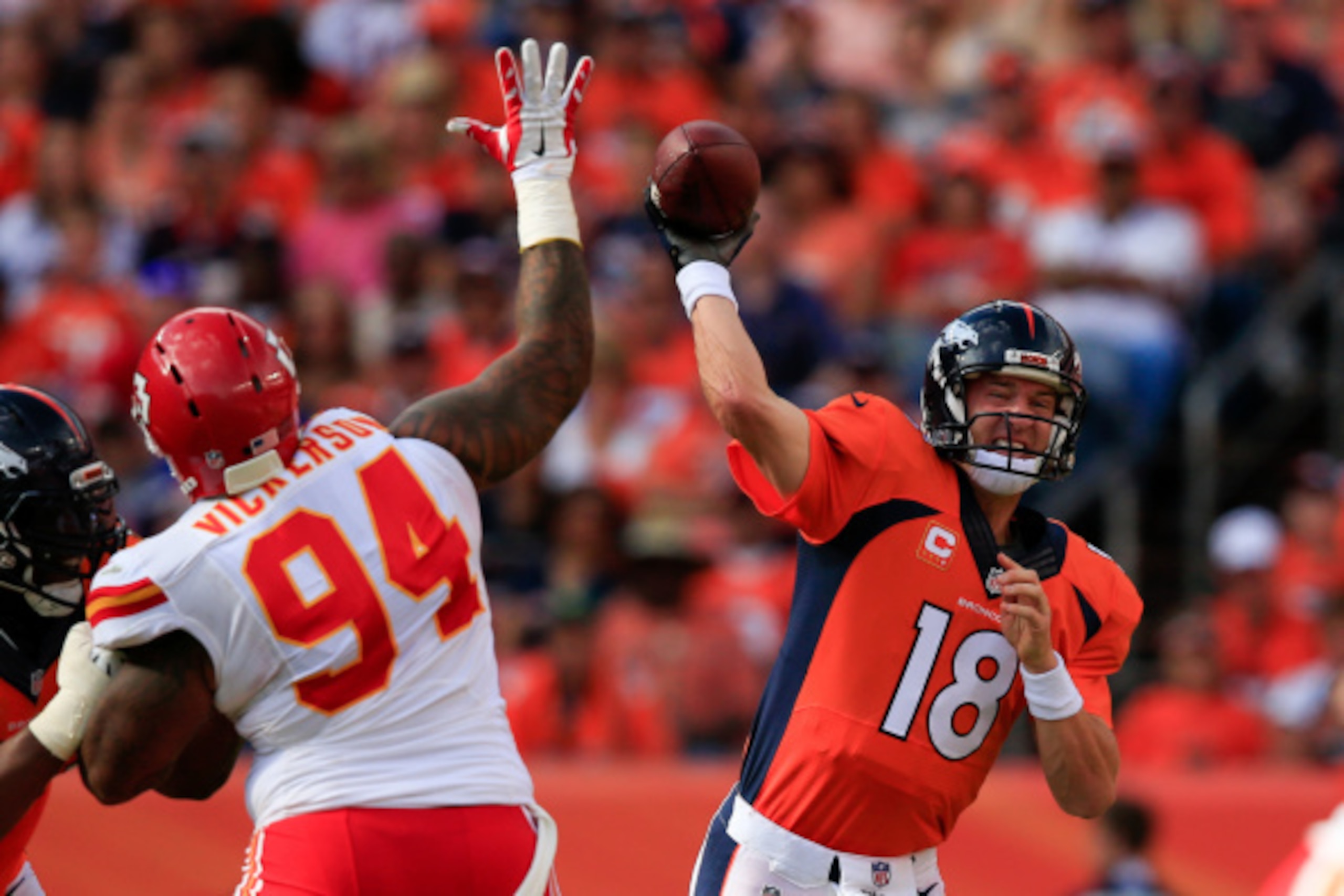 DENVER, CO - SEPTEMBER 14:  Quarterback Peyton Manning #18 of the Denver Broncos passes as Kevin Vickerson #94 of the Kansas City Chiefs attempts to block the pass during a game at Sports Authority Field at Mile High on September 14, 2014 in Denver, Color