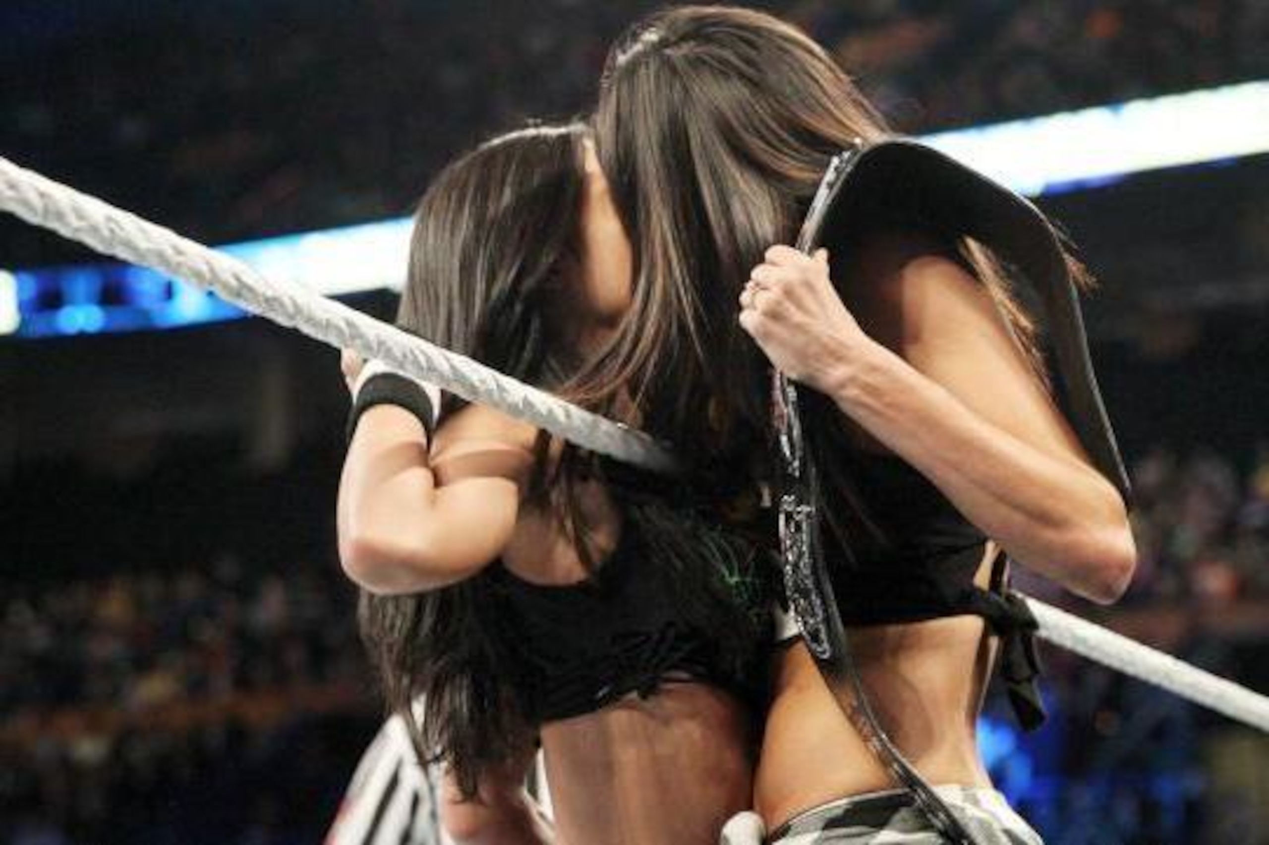 Brie Bella distracts AJ Lee with a kiss.