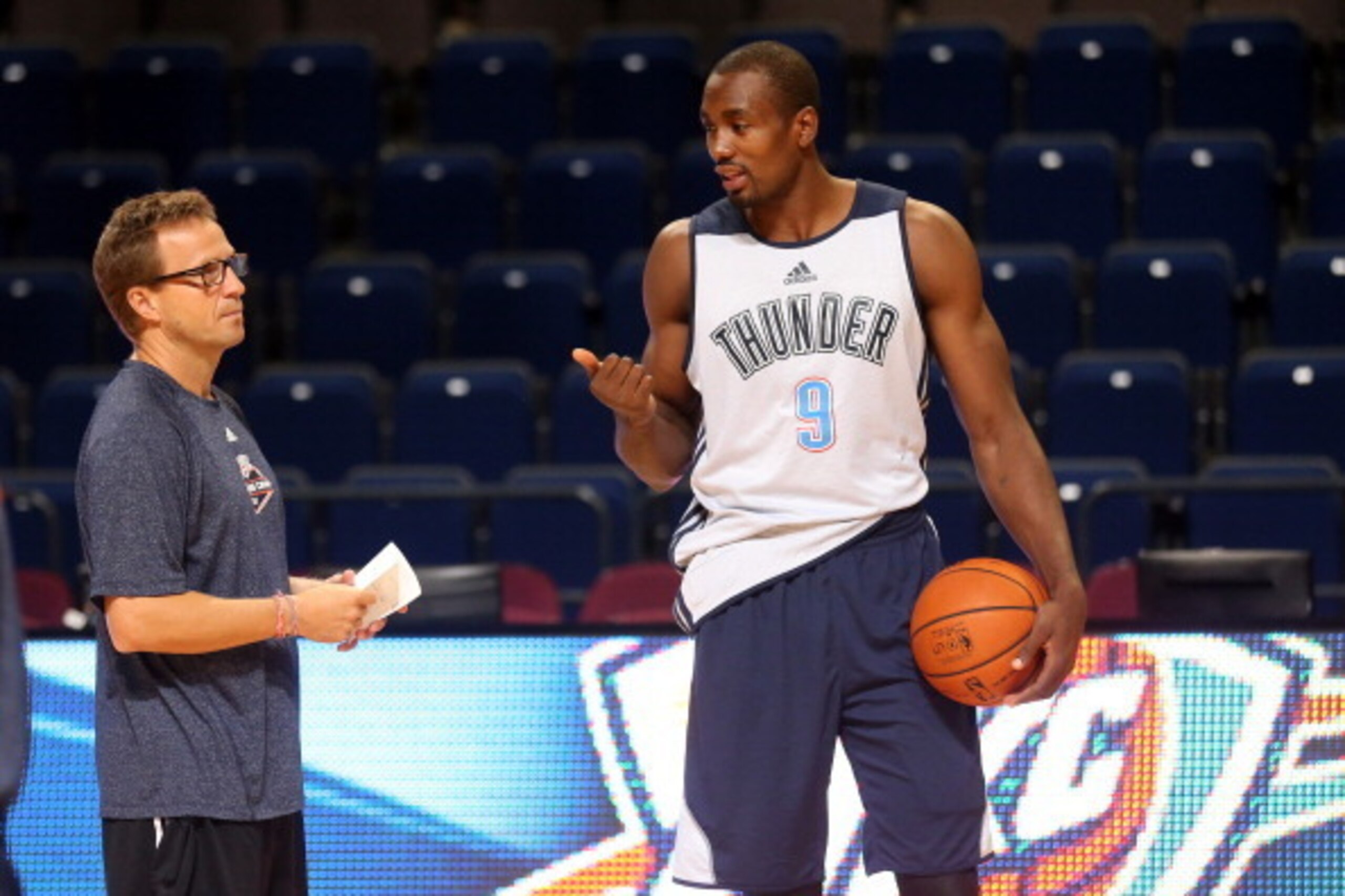 MANCHESTER, ENGLAND - OCTOBER 7: Serge Ibaka #9 of the Oklahoma City Thunder talks with head coach Scott Brooks as their team prepares for their game against the Philadelphia 76ers as part of the NBA Global Games on October 7, 2013 at the Phones 4u Arena 