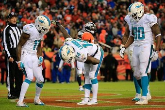 DENVER, CO - NOVEMBER 23:  Wide receiver Jarvis Landry #14 of the Miami Dolphins celebrates a third quarter touchdown against the Denver Broncos during a game at Sports Authority Field at Mile High on November 23, 2014 in Denver, Colorado.  (Photo by Doug