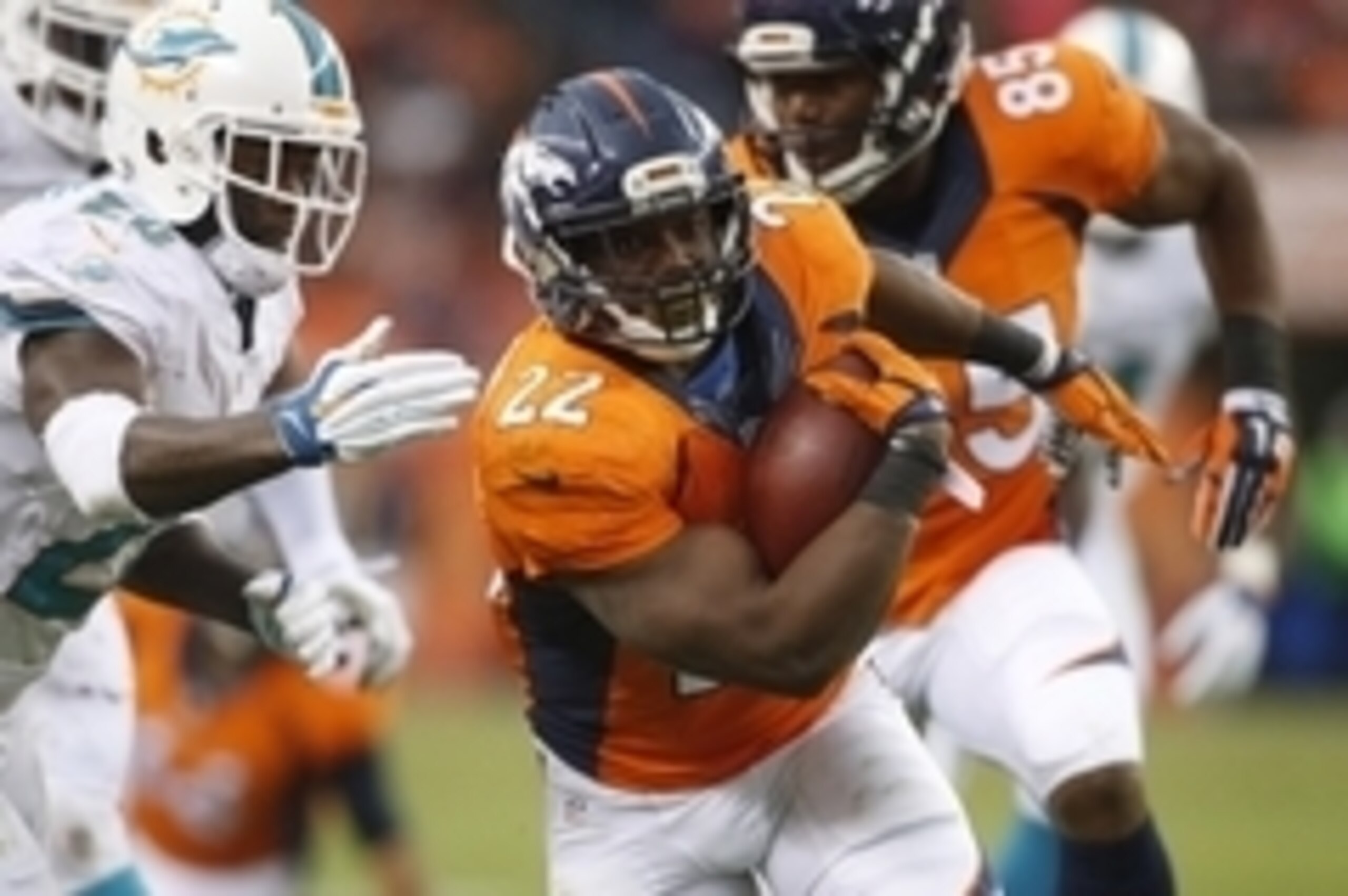 Nov 23, 2014; Denver, CO, USA; Denver Broncos running back C.J. Anderson (22) evades a tackle from Miami Dolphins strong safety Reshad Jones (20) during the first half at Sports Authority Field at Mile High. Mandatory Credit: Chris Humphreys-USA TODAY Spo