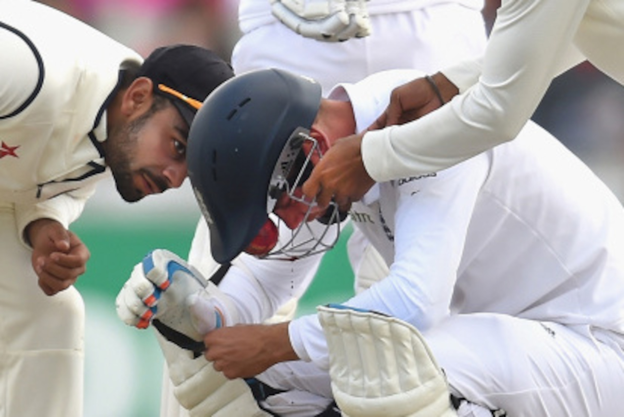 MANCHESTER, ENGLAND - AUGUST 09: Indian fielders attend to England batsman Stuart Broad after he is hit by a ball through the grill of his helmet from Varun Aaron, sustaining a broken nose during day three of the 4th Investec Test match between England a MANCHESTER, ENGLAND - AUGUST 09: Indian fielders attend to England batsman Stuart Broad after he is hit by a ball through the grill of his helmet from Varun Aaron, sustaining a broken nose during day three of the 4th Investec Test match between England a