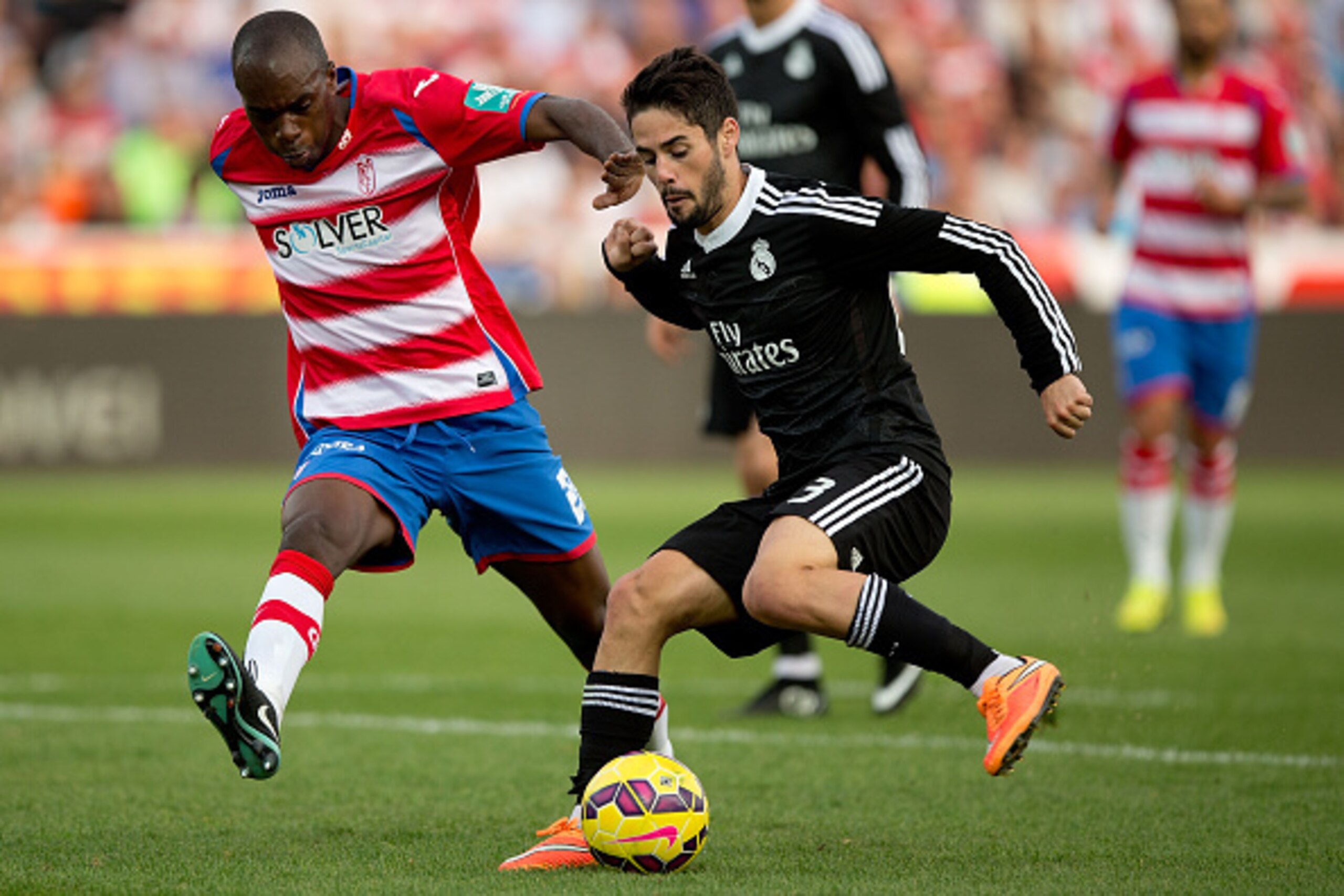 GRANADA, SPAIN - NOVEMBER 01: Francisco Roman Alarcon (Isco) (R) of Real Madrid CF competes for the ball with Allan Nyom (L) of Granada CF during the La Liga match between Granada CF and Real Madrid CF at Nuevo Estadio de Los Carmenes on November 1, 2014 