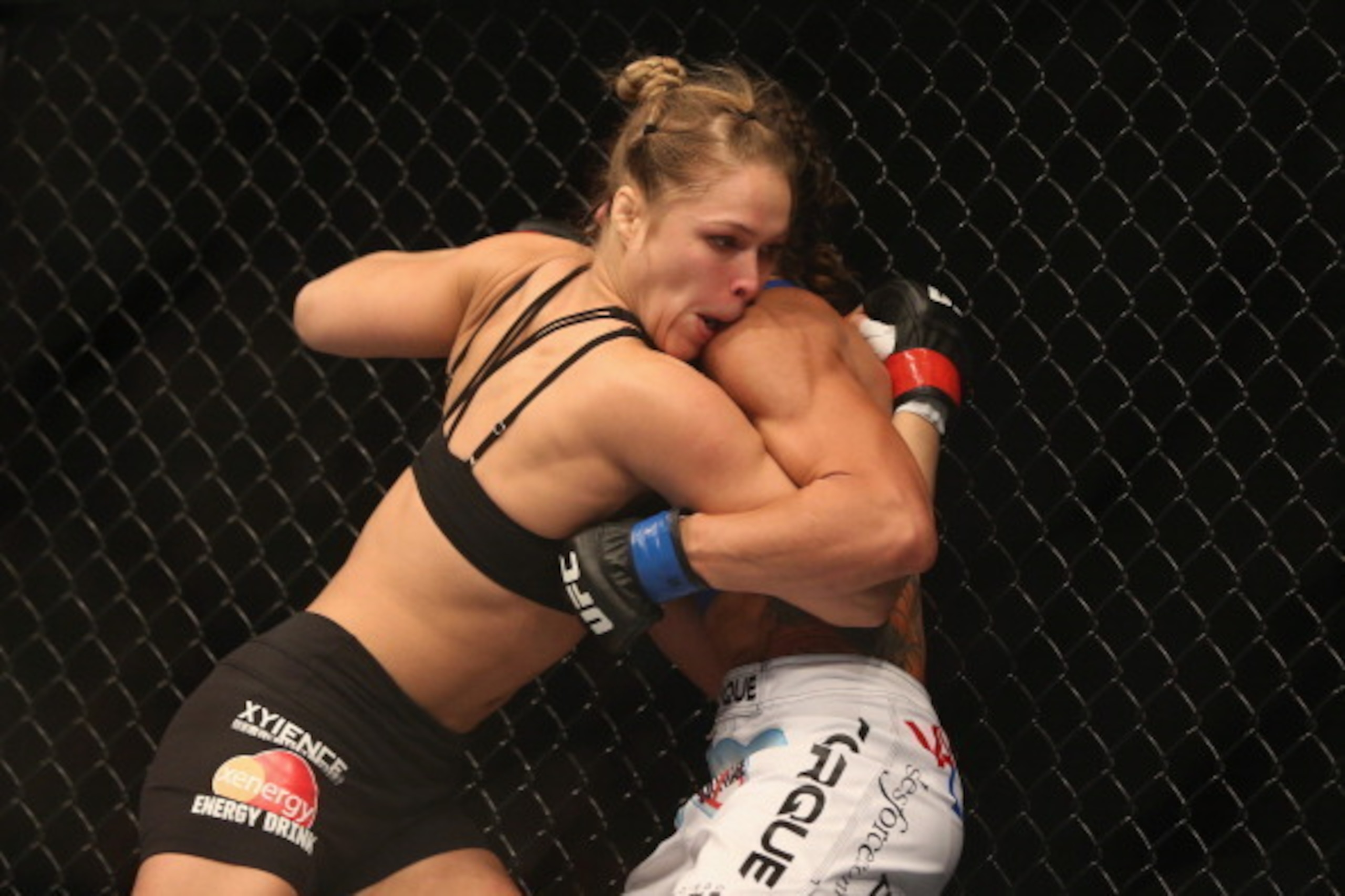 ANAHEIM, CA - FEBRUARY 23:  Ronda Rousey pins Liz Carmouche up against the fence in their UFC Bantamweight Title fight during UFC 157 at Honda Center on February 23, 2013 in Anaheim, California.  (Photo by Jeff Gross/Getty Images)