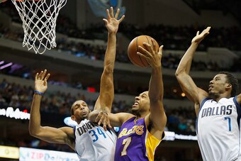 DALLAS, TX - NOVEMBER 21:  Xavier Henry #7 of the Los Angeles Lakers drives to the basket against Brandan Wright #34 of the Dallas Mavericks and Al-Farouq Aminu #7 of the Dallas Mavericks in the third quarter at American Airlines Center on November 21, 20