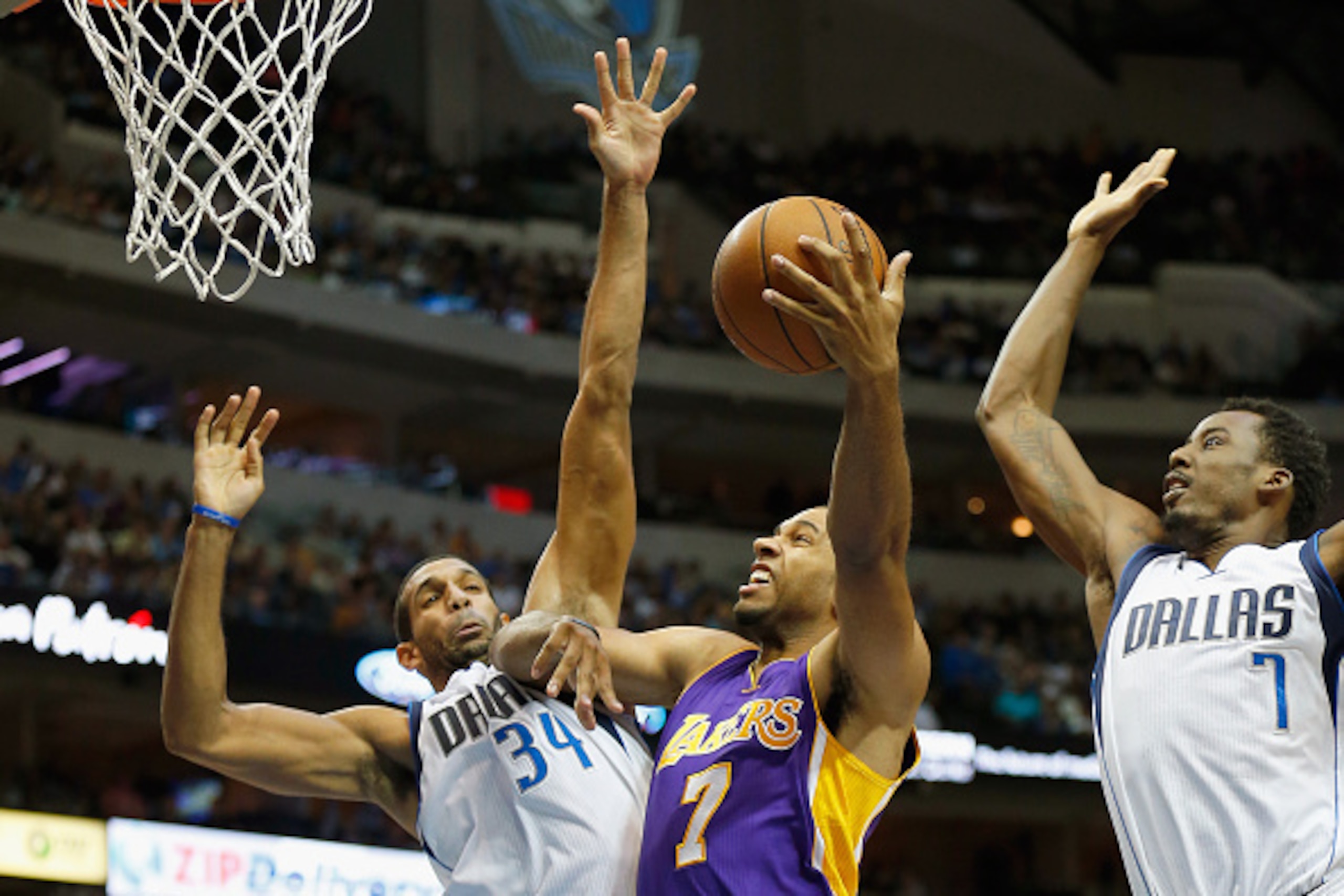 DALLAS, TX - NOVEMBER 21:  Xavier Henry #7 of the Los Angeles Lakers drives to the basket against Brandan Wright #34 of the Dallas Mavericks and Al-Farouq Aminu #7 of the Dallas Mavericks in the third quarter at American Airlines Center on November 21, 20