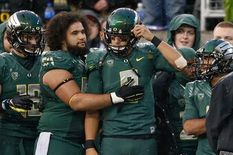 EUGENE, OR - NOVEMBER 22:  Quarterback Marcus Mariota #8 of the Oregon Ducks gets a hug from Hamani Stevens #54 after coming out of the game in the second half against the Colorado Buffaloes at Autzen Stadium on November 22, 2014 in Eugene, Oregon. The Du