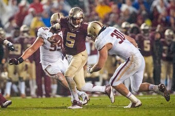 TALLAHASSEE, FL - NOVEMBER 22: Quarterback Jameis Winston #5 of the Florida State Seminoles looks for a hale in the Boston College Eagles line during the game at Doak Campbell Stadium on November 22, 2014 in Tallahassee, Florida. The Seminoles defeated th