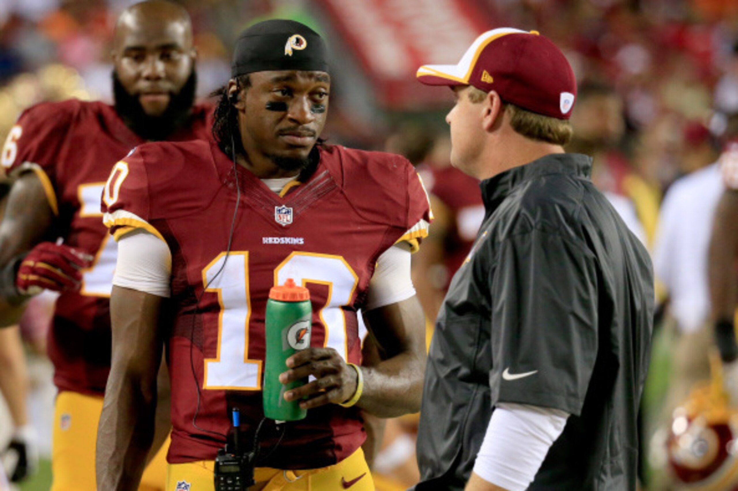 LANDOVER, MD - AUGUST 18: Quarterback Robert Griffin III #10 of the Washington Redskins talks with head coach Jay Gruden of the Washington Redskins  during a preseason game against the Cleveland Browns at FedExField on August 18, 2014 in Landover, Marylan