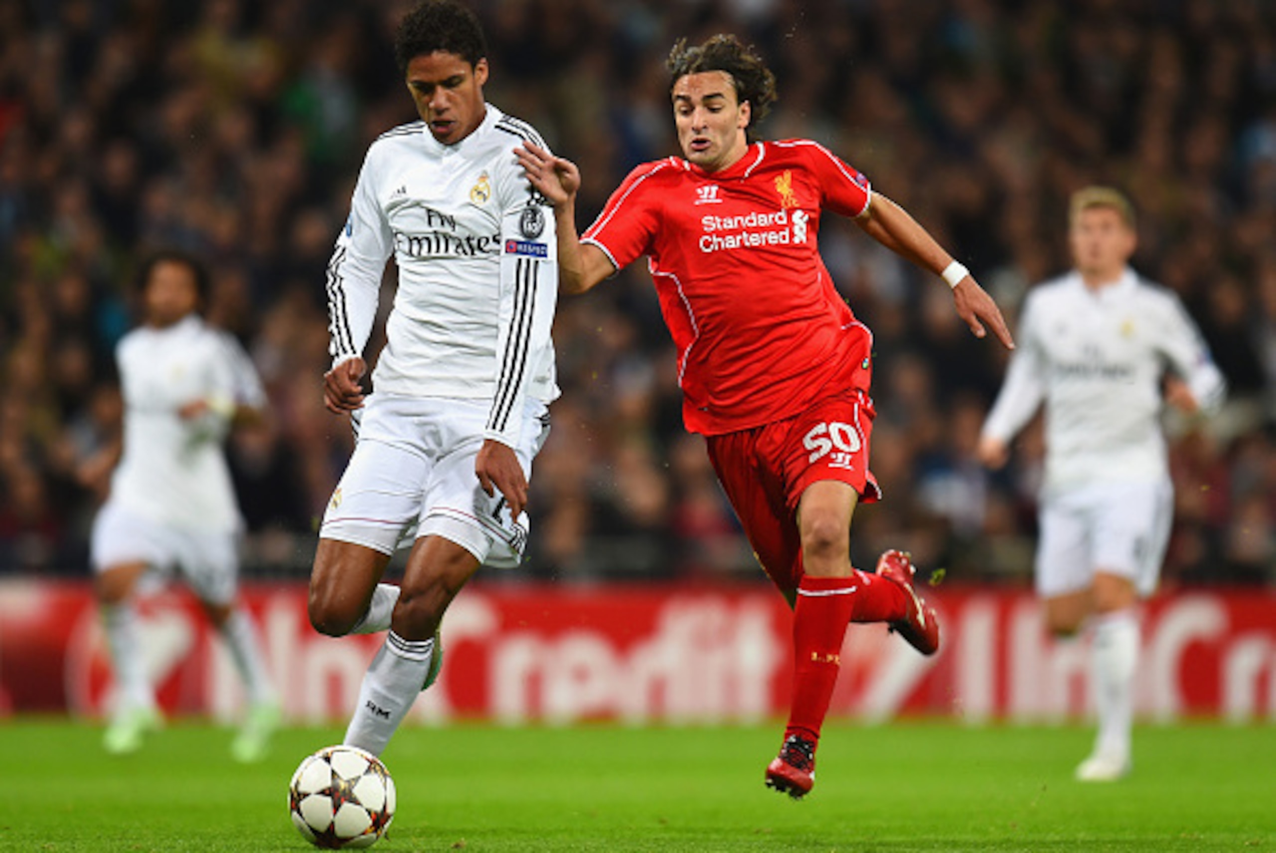 MADRID, SPAIN - NOVEMBER 04: Raphael Varane of Real Madrid CF and Lazar Markovic of Liverpool compete for the ball during the UEFA Champions League Group B match between Real Madrid CF and Liverpool FC at Estadio Santiago Bernabeu on November 4, 2014 in M