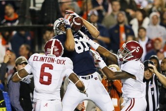 AUBURN, AL - NOVEMBER 30:  C.J. Uzomah #81 of the Auburn Tigers completes a third quarter touchdown reception for a touchdown against the defense of Ha Ha Clinton-Dix #6 and Cyrus Jones #5 of the Alabama Crimson Tide at Jordan-Hare Stadium on November 30,