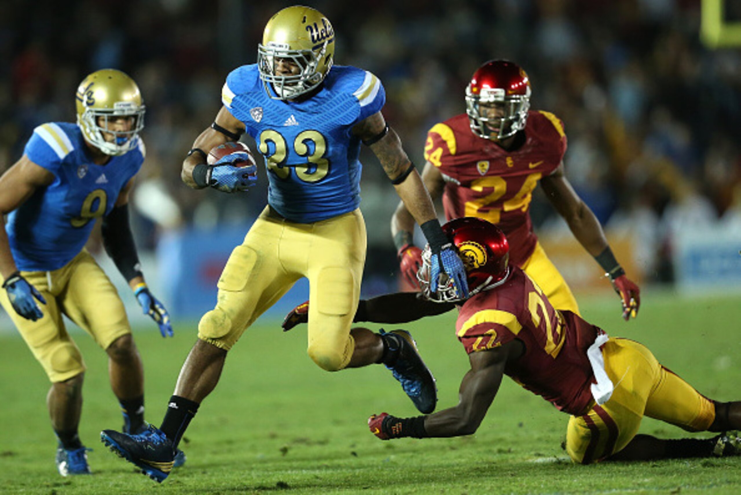 PASADENA, CA - NOVEMBER 22: Running back Nate Starks #23 of the UCLA Bruins carries the ball past defensive back Leon McQuay III #22 of the USC Trojans at the Rose Bowl on November 22, 2014 in Pasadena, California. UCLA on 38-20. (Photo by Stephen Dun PASADENA, CA - NOVEMBER 22: Running back Nate Starks #23 of the UCLA Bruins carries the ball past defensive back Leon McQuay III #22 of the USC Trojans at the Rose Bowl on November 22, 2014 in Pasadena, California. UCLA on 38-20. (Photo by Stephen Dun