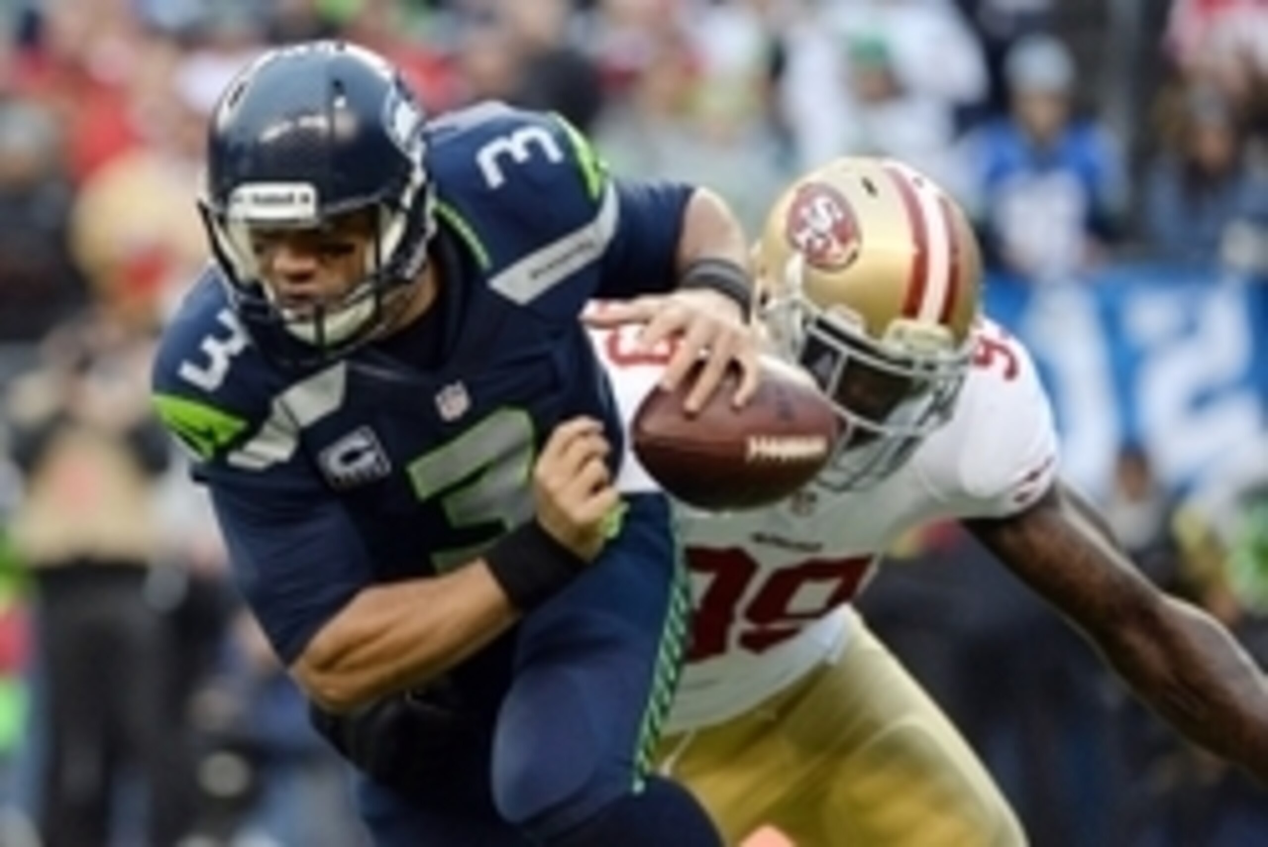 Jan 19, 2014; Seattle, WA, USA; Seattle Seahawks quarterback Russell Wilson (3) fumbles the ball after being pressured by San Francisco 49ers outside linebacker Aldon Smith (99) during the first half of the 2013 NFC Championship football game at CenturyLi