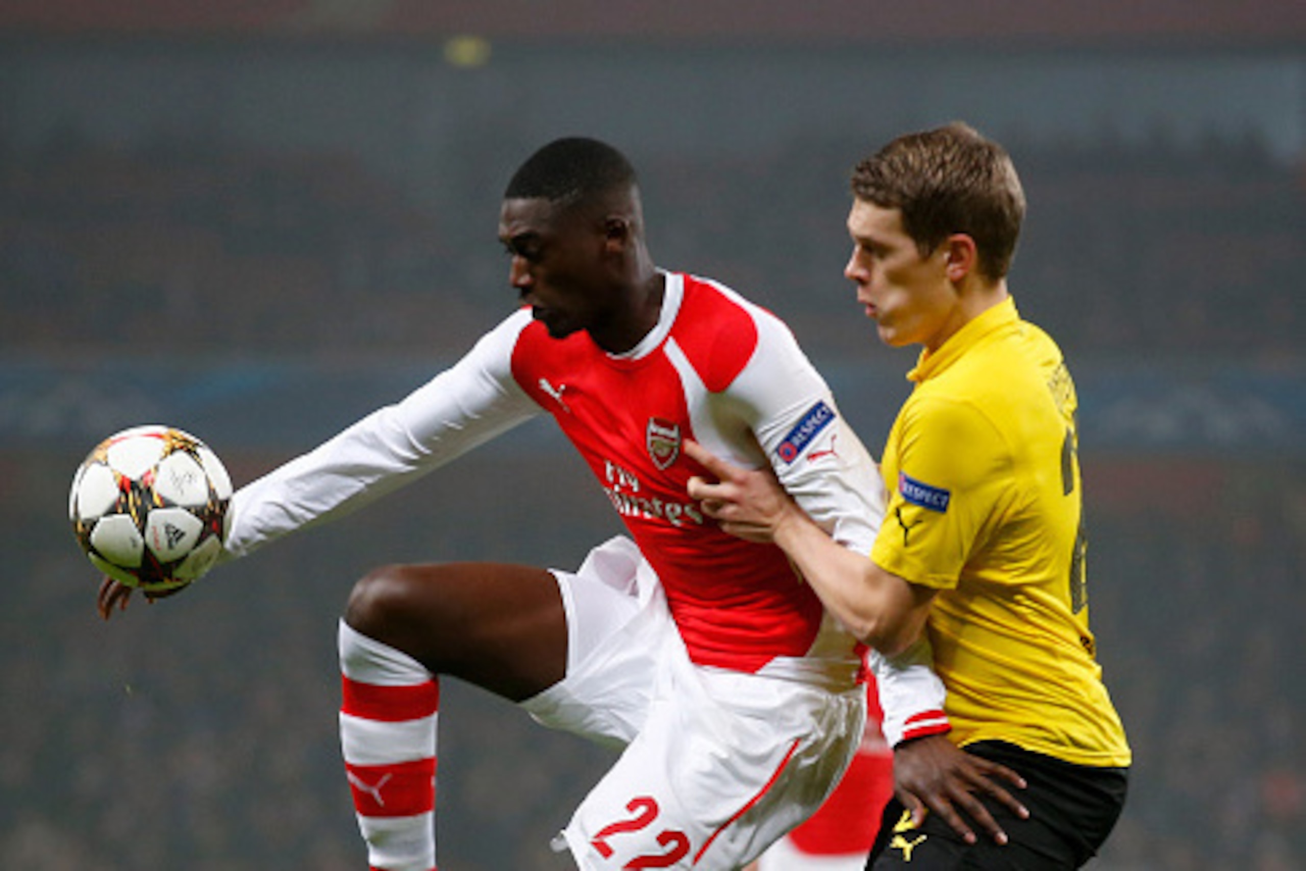 LONDON, ENGLAND - NOVEMBER 26:  Yaya Sanogo of Arsenal controls the ball under pressure from Matthias Ginter of Borussia Dortmund during the UEFA Champions League Group D match between Arsenal and Borussia Dortmund at the Emirates Stadium on November 26, 
