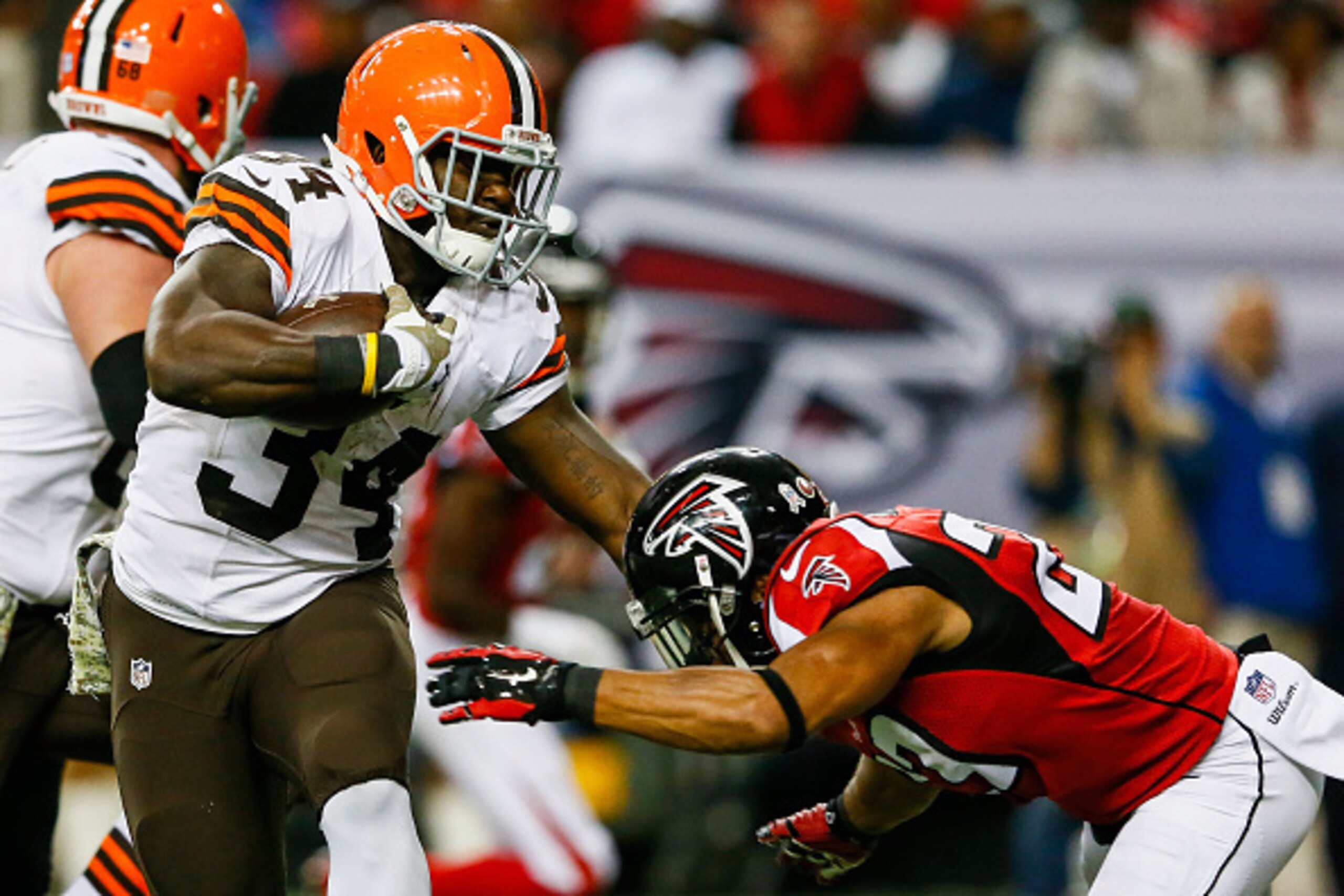ATLANTA, GA - NOVEMBER 23:  Isaiah Crowell #34 of the Cleveland Browns stiff arms Robert Alford #23 of the Atlanta Falcons on a touchdown run in the second half at Georgia Dome on November 23, 2014 in Atlanta, Georgia.  (Photo by Kevin C. Cox/Getty Images