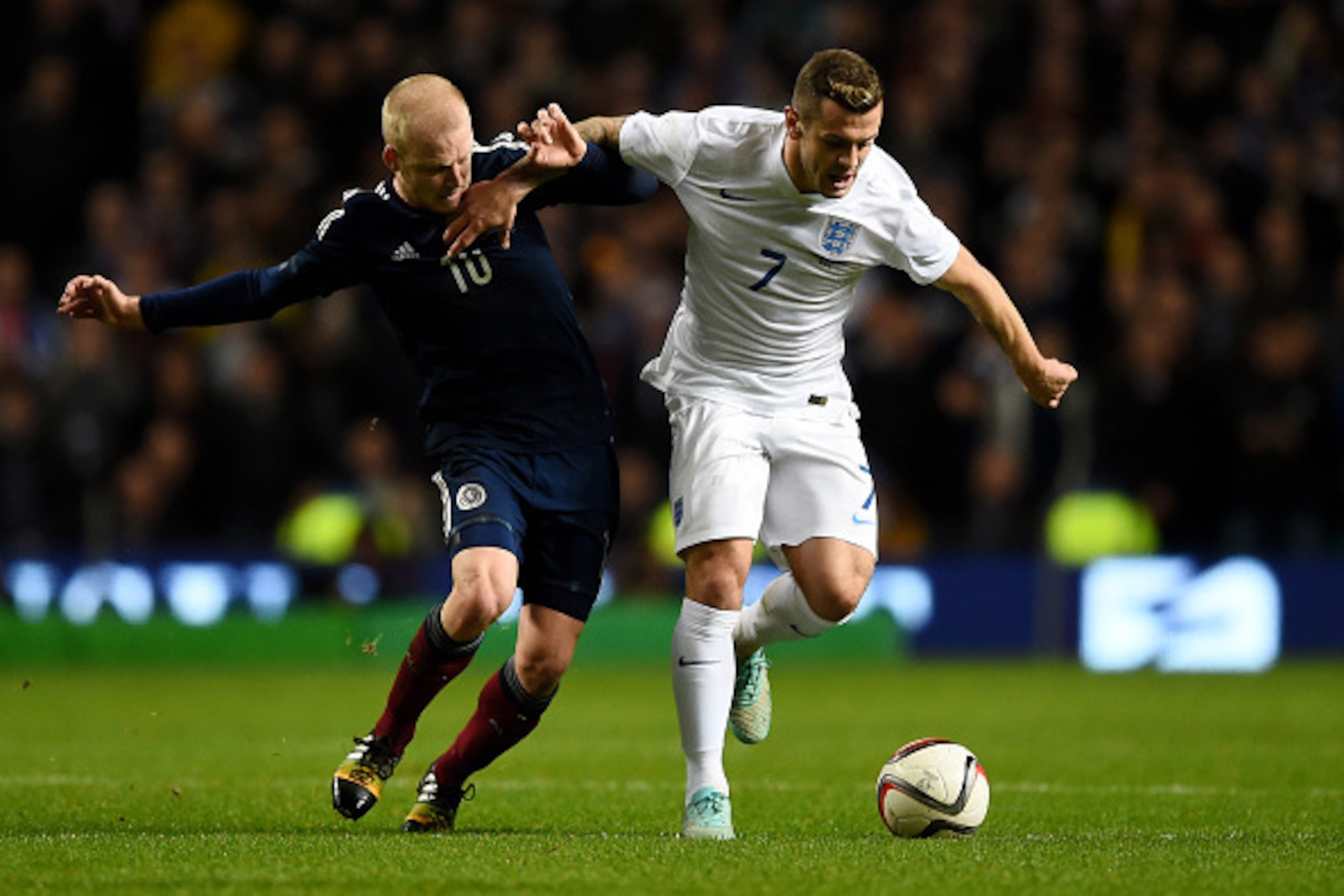 GLASGOW, SCOTLAND - NOVEMBER 18:  Jack Wilshere of England is challenged by Steven Naismith of Scotland during the International Friendly match between Scotland and England at Celtic Park Stadium on November 18, 2014 in Glasgow, Scotland.  (Photo by Shaun