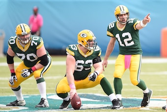 Oct 12, 2014; Miami Gardens, FL, USA; Green Bay Packers quarterback Aaron Rodgers (12) calls an audible at the line of scrimmage as Green Bay Packers guard T.J. Lang (70) and Green Bay Packers center Corey Linsley (63) listen at Sun Life Stadium. Mandator