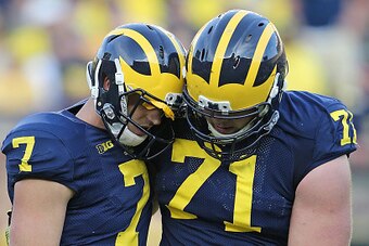 ANN ARBOR, MI - SEPTEMBER 27: Quarterback Shane Morris #7 of the Michigan Wolverines is helped off the field by Ben Braden #71 during the fourth quarter of the game against the Minnesota Golden Gophers at Michigan Stadium on September 27, 2014 in Ann Arbo