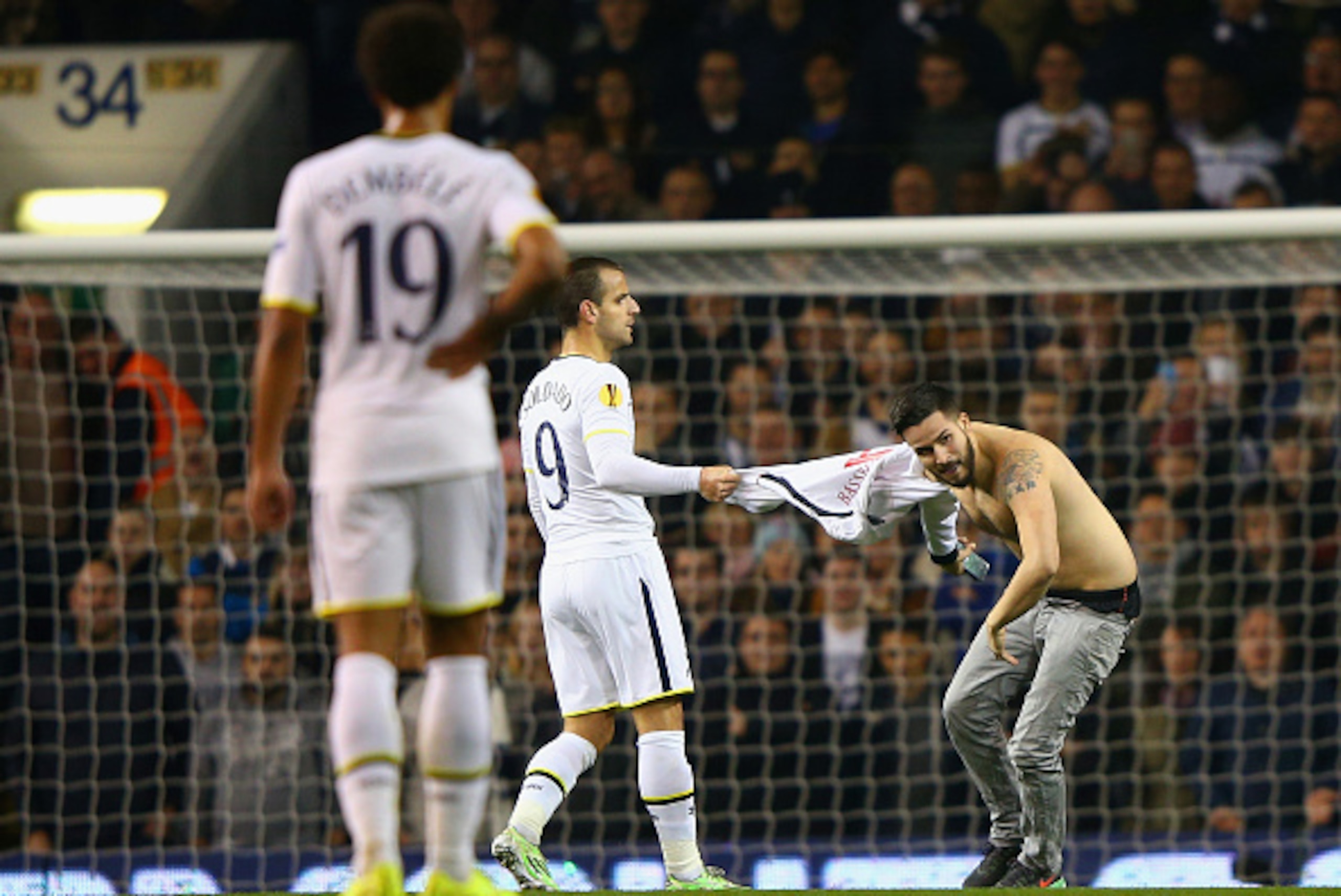 LONDON, ENGLAND - NOVEMBER 27: Roberto Soldado of Spurs pulls on the shirt of a second pitch invader  during the UEFA Europa League group C match between Tottenham Hotspur FC and FK Partizan at White Hart Lane on November 27, 2014 in London, United Kingdo