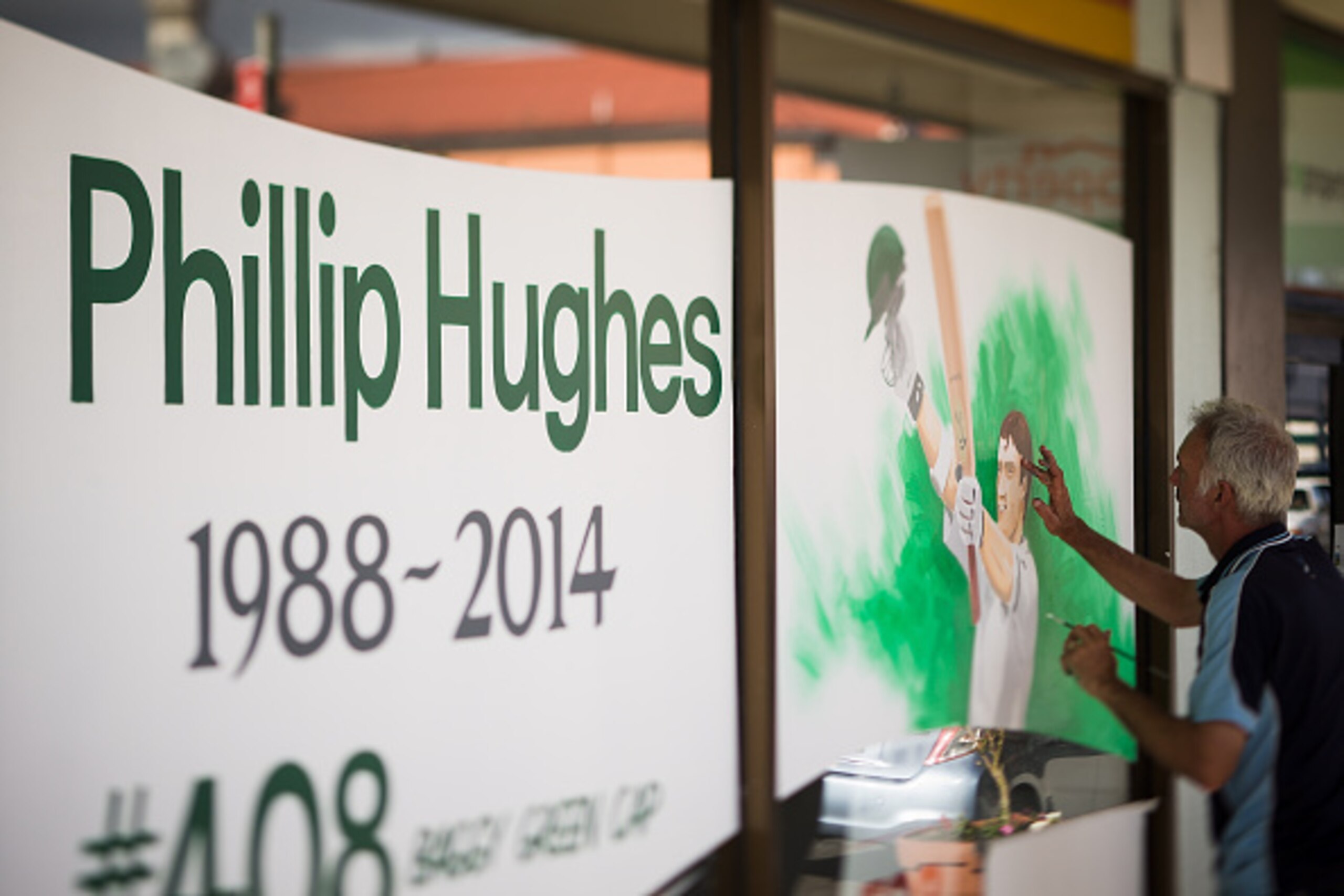 SYDNEY, AUSTRALIA - NOVEMBER 28:  (EDITORS NOTE: This image was created using a tilt shift lens) A portrait is painted on a store display in memory of Australian cricketer Phillip Hughes on November 28, 2014 in Phillip Hughes' hometown Macksville, Austral
