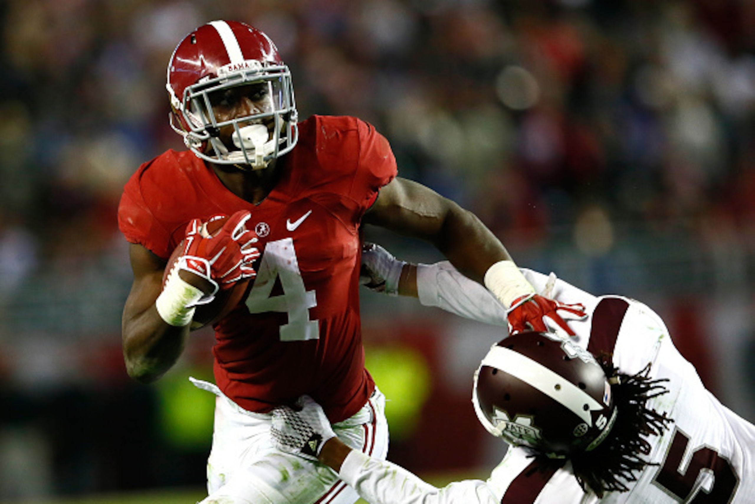 TUSCALOOSA, AL - NOVEMBER 15:  T.J. Yeldon #4 of the Alabama Crimson Tide stiff arms Jamerson Love #5 of the Mississippi State Bulldogs at Bryant-Denny Stadium on November 15, 2014 in Tuscaloosa, Alabama.  (Photo by Kevin C. Cox/Getty Images)