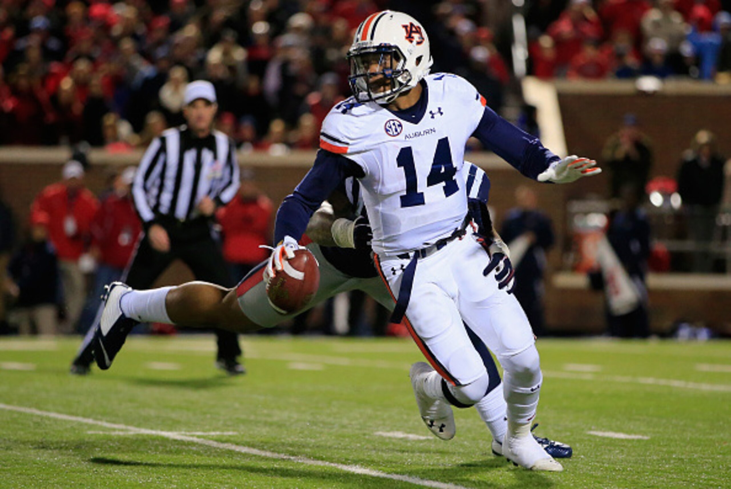 OXFORD, MS - NOVEMBER 01:  Quarterback Nick Marshall #14 of the Auburn Tigers eludes Robert Nkemdiche #5 of the Mississippi Rebels and completes a first down pass in the third quarter at Vaught-Hemingway Stadium on November 1, 2014 in Oxford, Mississippi.