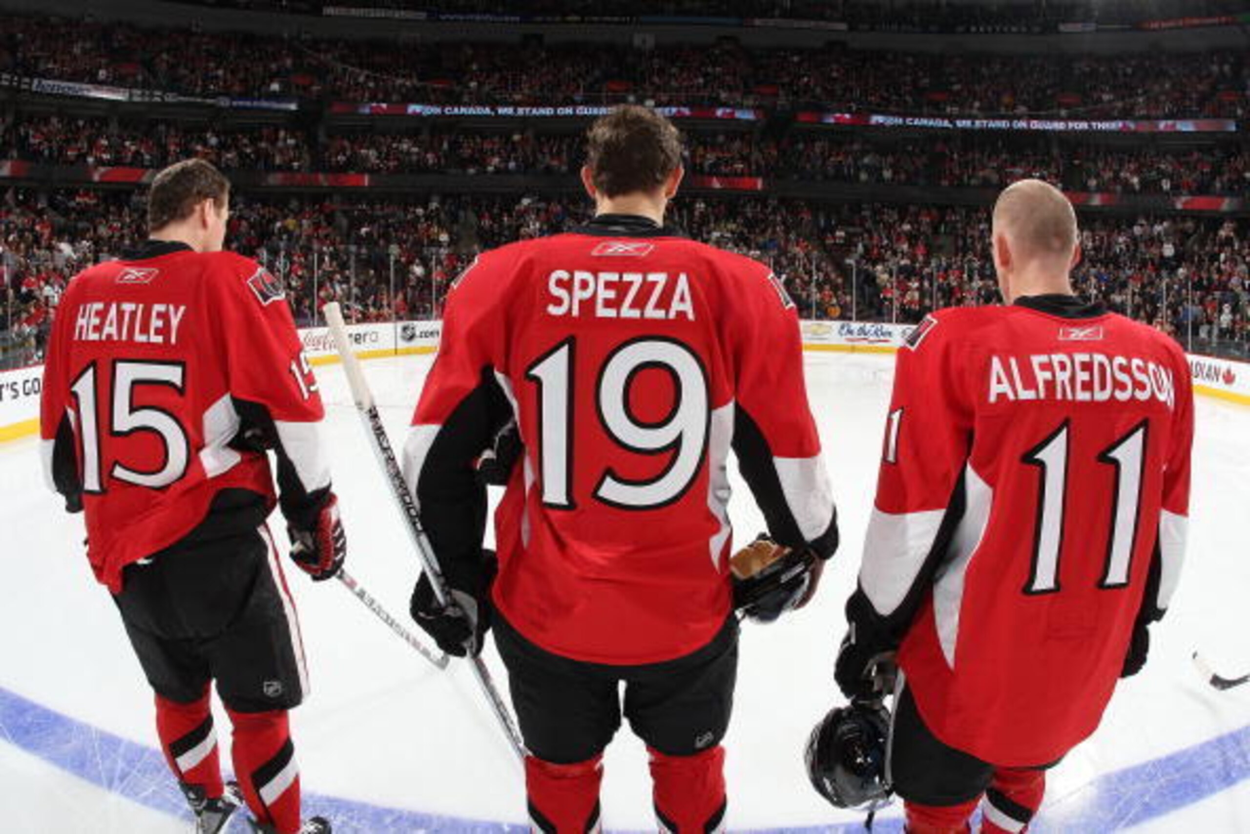 OTTAWA - DECEMBER 1: Dany Heatley #15, Jason Spezza #19 and Daniel Alfredsson #11 of the Ottawa Senators line up on the blue line during the singing of the national anthems before a game against the New York Rangers at Scotiabank Place on December 1, 2007