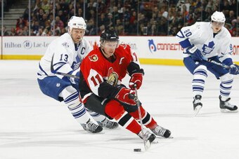 OTTAWA - FEBRUARY 3:  Daniel Alfredsson #11 of the Ottawa Senators controls the puck in the defensive zone as Mats Sundin #13 of the Toronto Maple Leafs pursues the play during their NHL game on February 3, 2007 at the Scotiabank Place in Ottawa, Canada. 