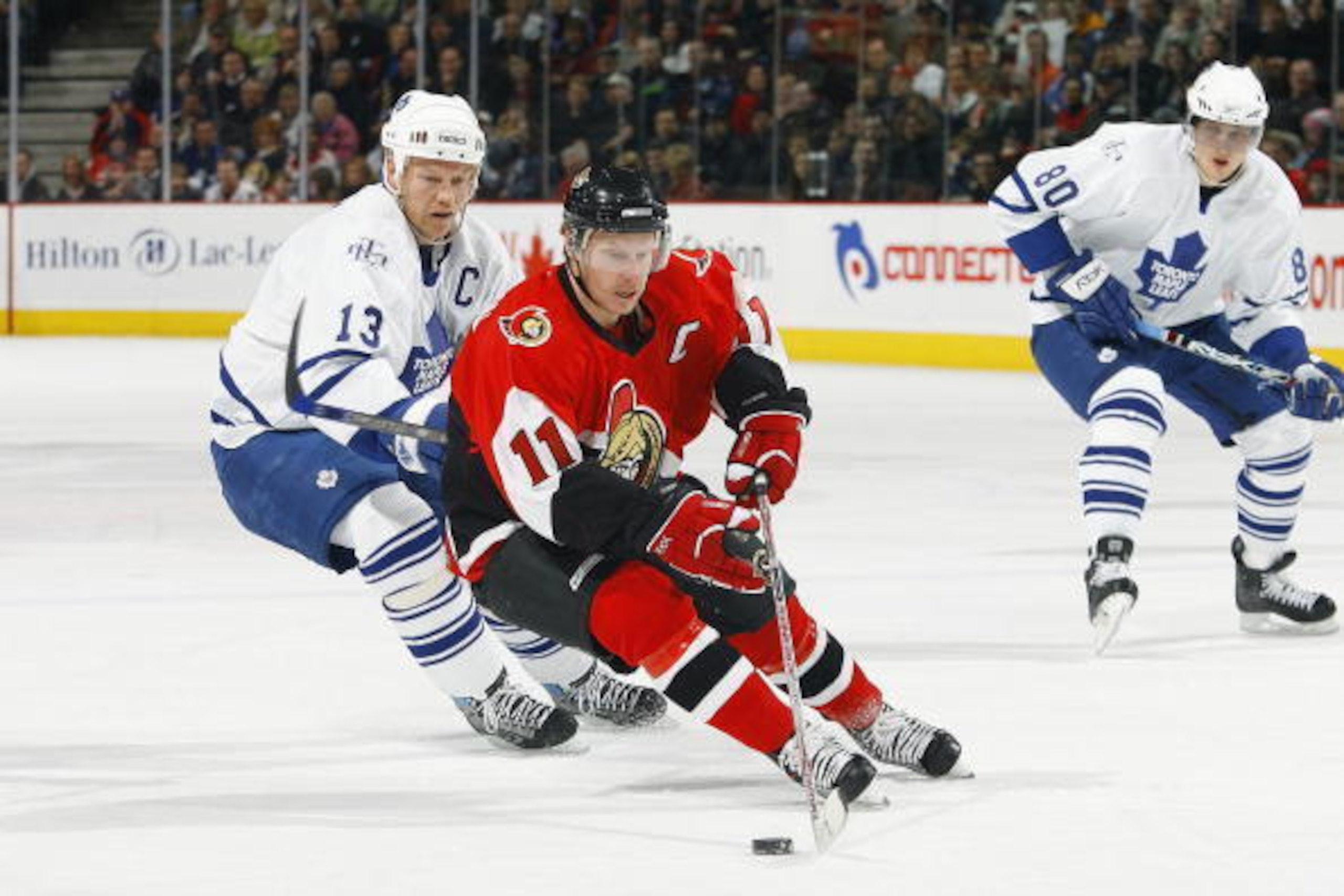 OTTAWA - FEBRUARY 3:  Daniel Alfredsson #11 of the Ottawa Senators controls the puck in the defensive zone as Mats Sundin #13 of the Toronto Maple Leafs pursues the play during their NHL game on February 3, 2007 at the Scotiabank Place in Ottawa, Canada. 