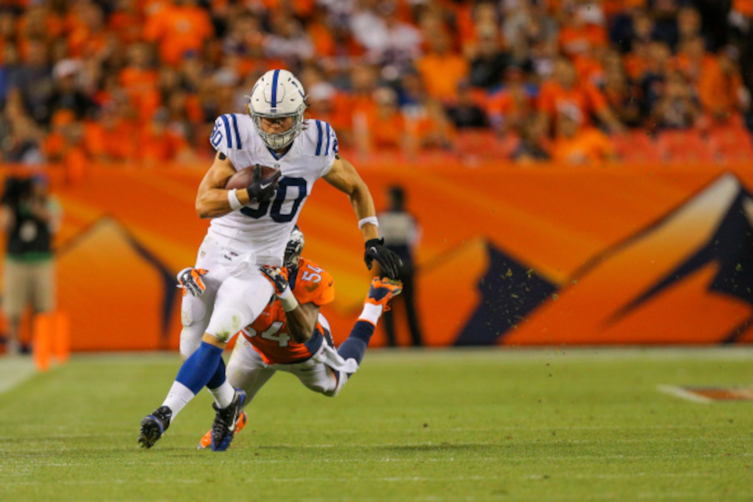DENVER, CO - SEPTEMBER 7:  Tight end Coby Fleener #80 of the Indianapolis Colts is wrapped up by linebacker Brandon Marshall #54 of the Denver Broncos after making a first down during a game at Sports Authority Field at Mile High on September 7, 2014 in D
