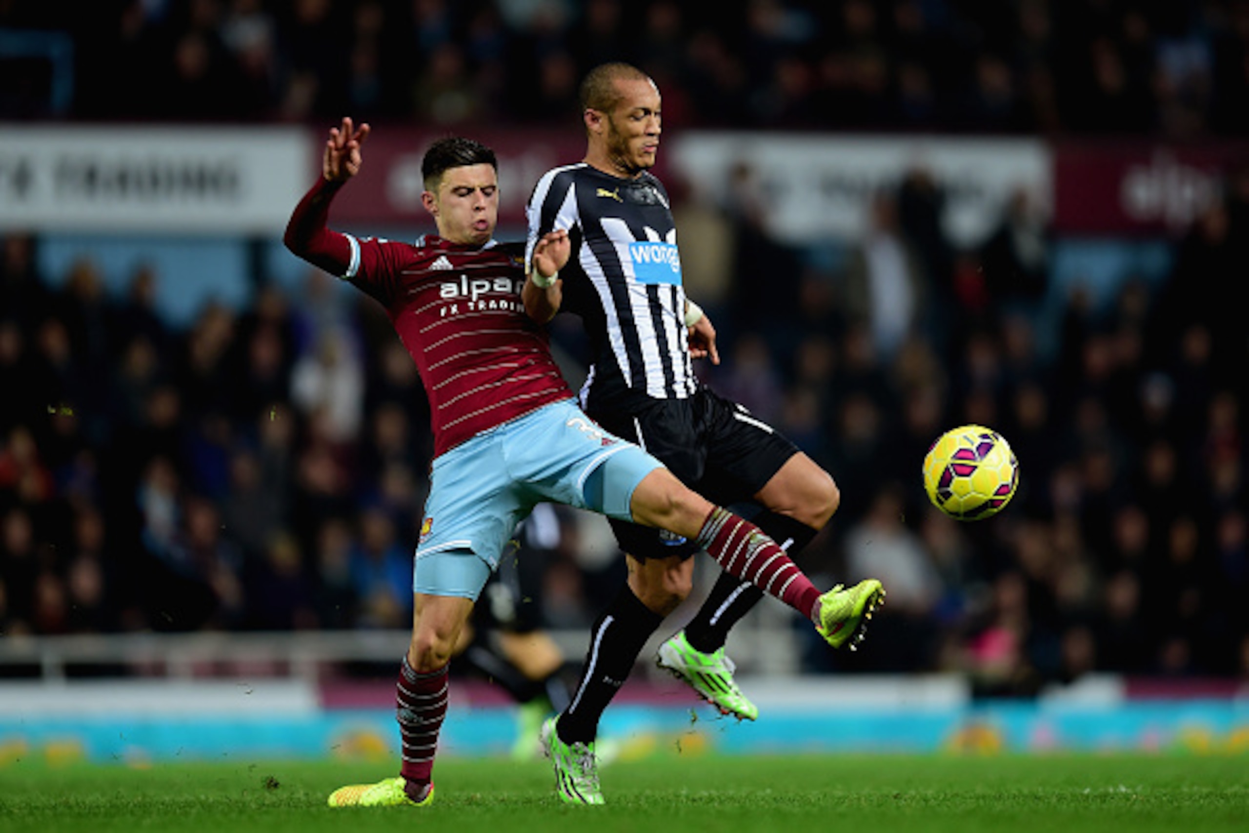 LONDON, ENGLAND - NOVEMBER 29:  Aaron Cresswell of West Ham and Yoan Gouffran of Newcastle United fight for the ball during the Barclays Premier League match between West Ham United and Newcastle United at Boleyn Ground on November 29, 2014 in London, Eng