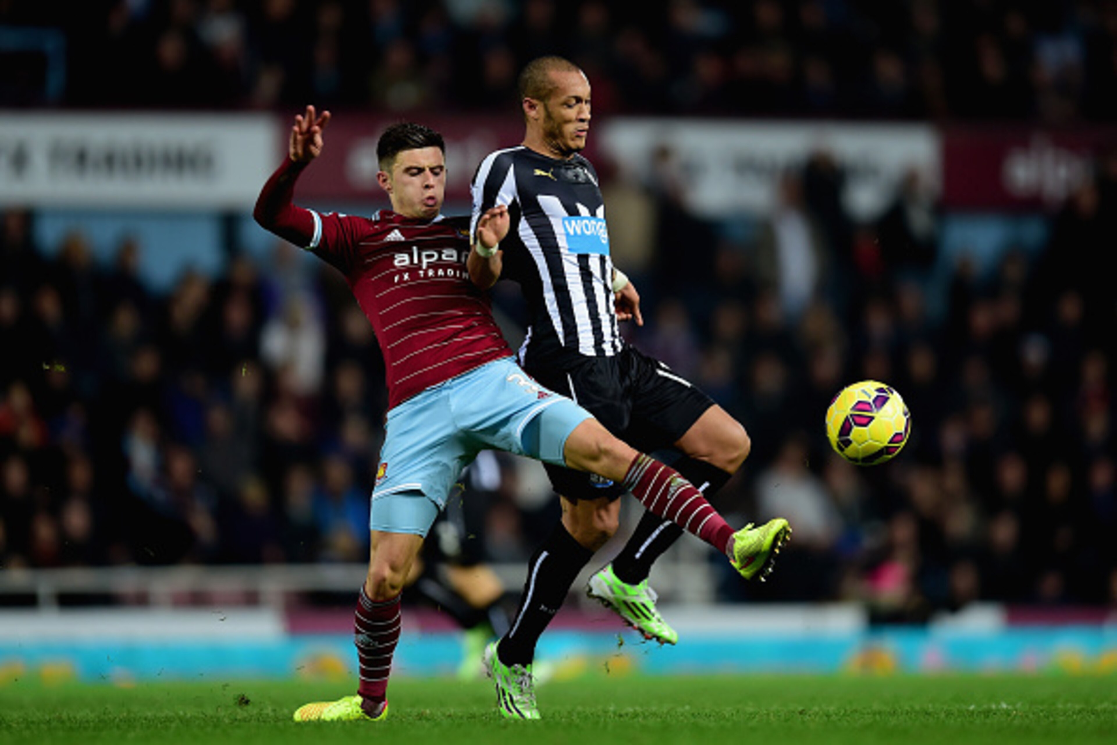 LONDON, ENGLAND - NOVEMBER 29:  Aaron Cresswell of West Ham and Yoan Gouffran of Newcastle United fight for the ball during the Barclays Premier League match between West Ham United and Newcastle United at Boleyn Ground on November 29, 2014 in London, Eng