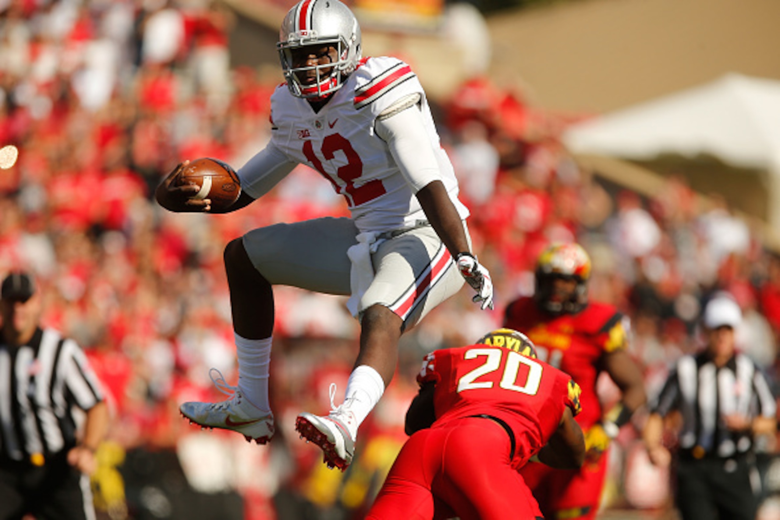 COLLEGE PARK, MD - OCTOBER 04:  Quarterback Cardale Jones #12 of the Ohio State Buckeyes hurdles safety Anthony Nixon #20 of the Maryland Terrapins during the fourth quarter of Ohio State's 52-24 win at Byrd Stadium on October 4, 2014 in College Park, Mar