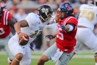 Nov 29, 2014; Oxford, MS, USA; Mississippi State Bulldogs quarterback Dak Prescott (15) stiff arms Mississippi Rebels defensive back Cody Prewitt (25) during the game at Vaught-Hemingway Stadium. Mandatory Credit: Spruce Derden-USA TODAY Sports