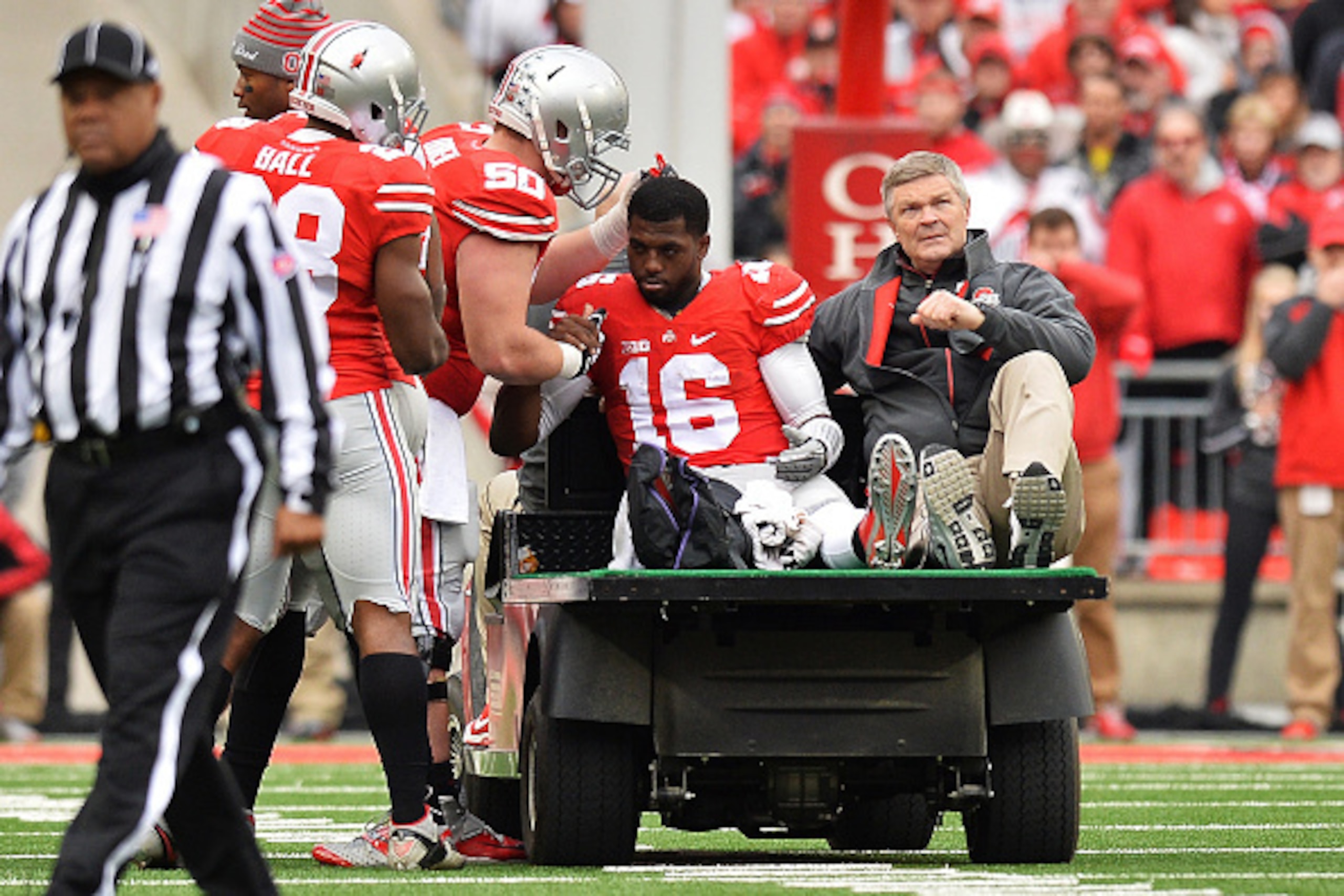 COLUMBUS, OH - NOVEMBER 29:  Quarterback J.T. Barrett #16 of the Ohio State Buckeyes is comforted by Jacoby Boren #50 of the Ohio State Buckeyes as Barrett is taken off the field after injuring his leg in the fourth quarter against the Michigan Wolverines