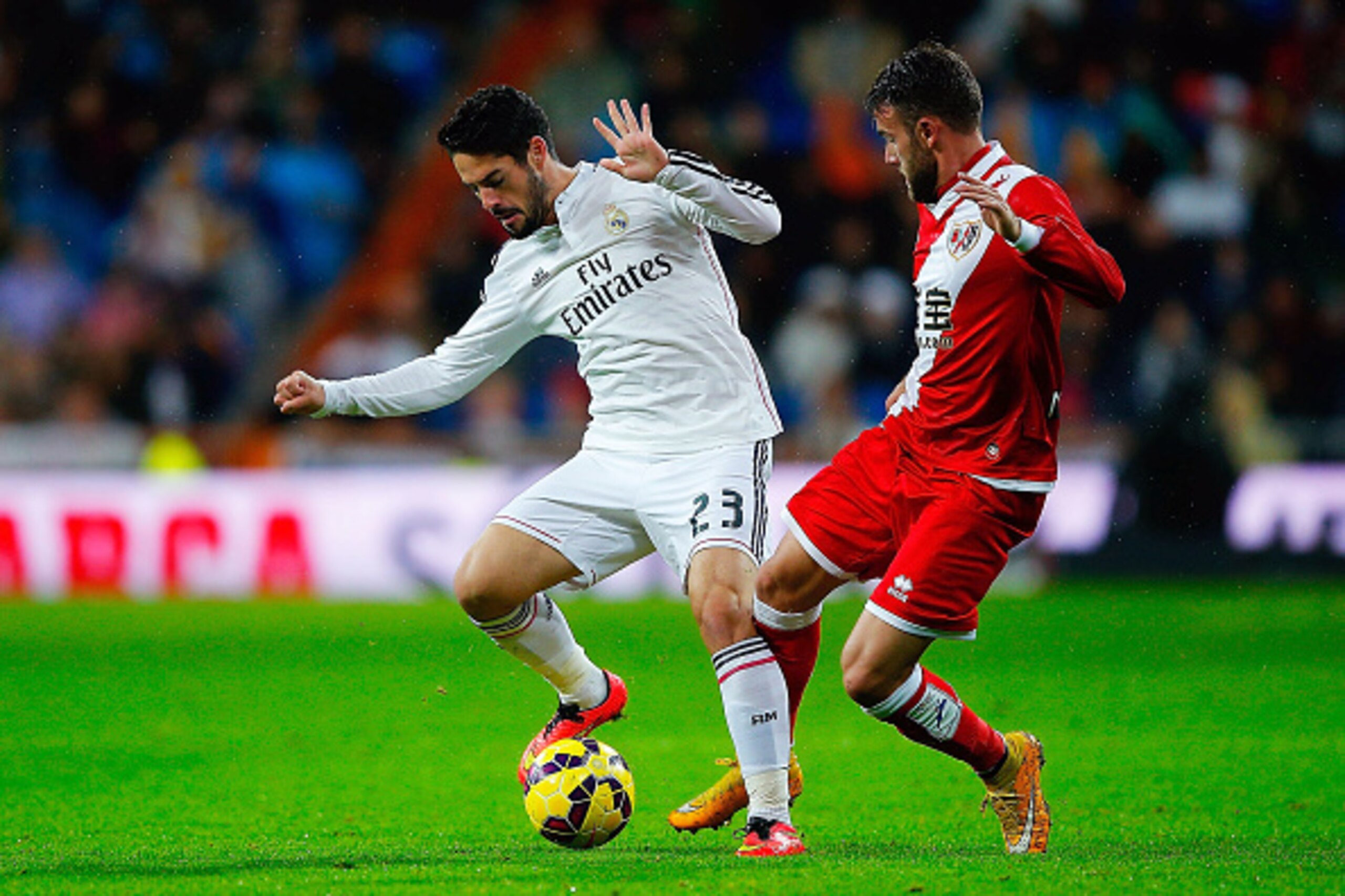 MADRID, SPAIN - NOVEMBER 08: Francisco Roman Alarcon alias Isco (L) of Real Madrid CF competes for the ball with Joaquin Jose Marin alias Quini (R) of Rayo Vallecano de Madrid during the La Liga match between Real Madrid CF and Rayo Vallecano de Madrid at