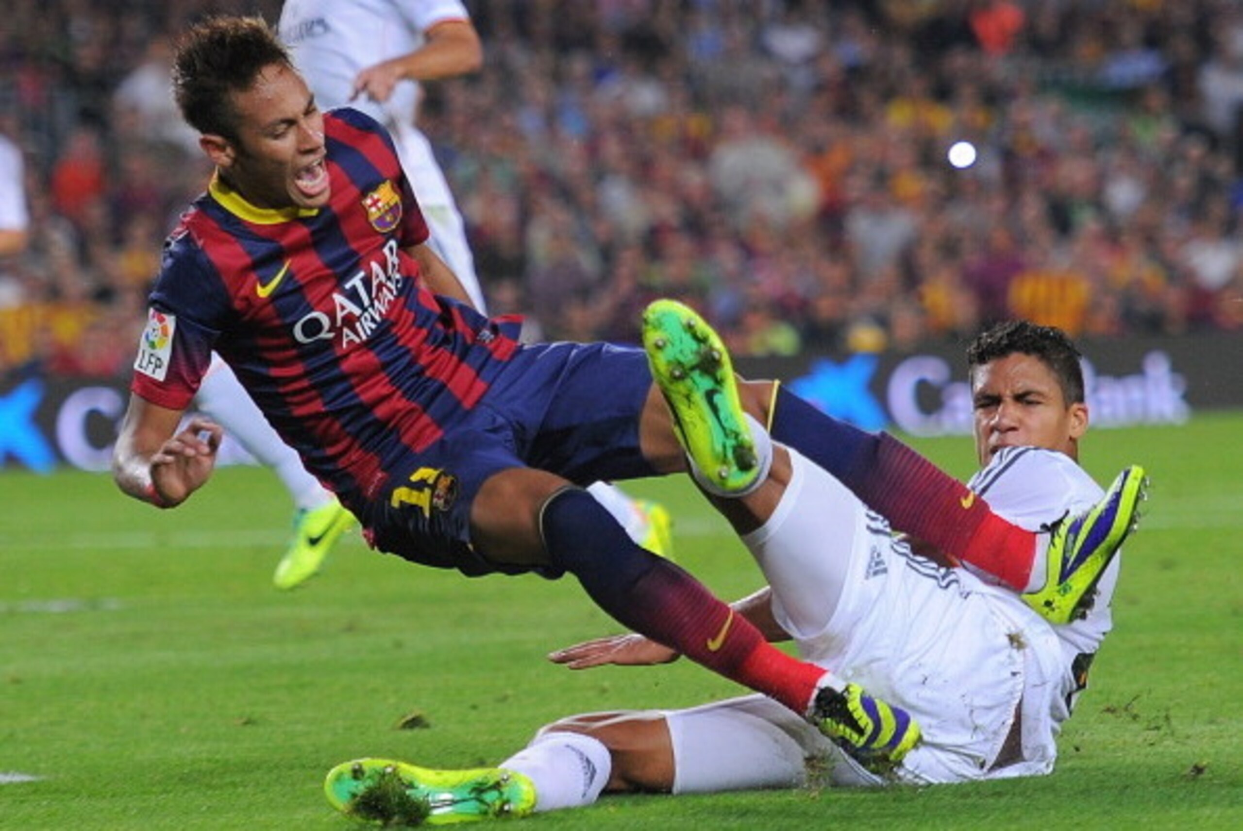 BARCELONA, SPAIN - OCTOBER 26: Neymar of FC Barcelona is brought down in a tackle by Raphael Varane of Real Madrid CF during the La Liga match between FC Barcelona and Real Madrid CF at Camp Nou stadium on October 26, 2013 in Barcelona, Spain. (Photo by BARCELONA, SPAIN - OCTOBER 26: Neymar of FC Barcelona is brought down in a tackle by Raphael Varane of Real Madrid CF during the La Liga match between FC Barcelona and Real Madrid CF at Camp Nou stadium on October 26, 2013 in Barcelona, Spain. (Photo by