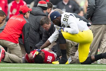 Nov 29, 2014; Columbus, OH, USA; Michigan Wolverines quarterback Devin Gardner (98) checks on Ohio State Buckeyes quarterback J.T. Barrett (16) after Barret was injured at Ohio Stadium. Mandatory Credit: Greg Bartram-USA TODAY Sports