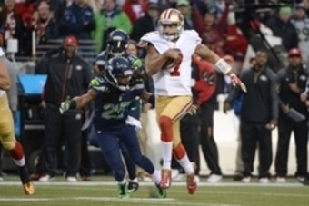 Jan 19, 2014; Seattle, WA, USA; San Francisco 49ers quarterback Colin Kaepernick (7) runs the football against Seattle Seahawks cornerback Richard Sherman (25) during the first half of the 2013 NFC Championship football game at CenturyLink Field. The Seah