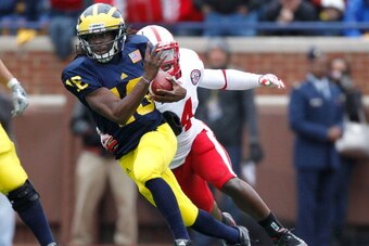 ANN ARBOR, MI - NOVEMBER 19:  Denard Robinson #16 of the Michigan Wolverines tries to escape the tackle of Lavonte David #4 of the Nebraska Cornhuskers during a first quarter run at Michigan Stadium on November 19, 2011 in Ann Arbor, Michigan. (Photo by G