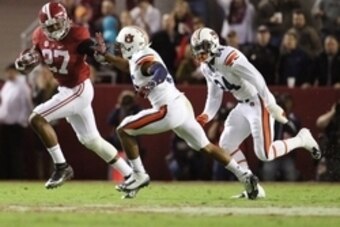 Nov 29, 2014; Tuscaloosa, AL, USA; Alabama Crimson Tide running back Derrick Henry (27) carries the ball past Auburn Tigers defensive back Joe Turner (35) and  Derrick Moncrief (24) in the fourth quarter at Bryant-Denny Stadium. Mandatory Credit: Marvin G