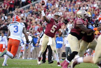 Nov 29, 2014; Tallahassee, FL, USA; Florida State Seminoles quarterback Jameis Winston (5) throws the ball as he is pressured by Florida Gators linebacker Antonio Morrison (3) during the first half at Doak Campbell Stadium. Mandatory Credit: Melina Vastol