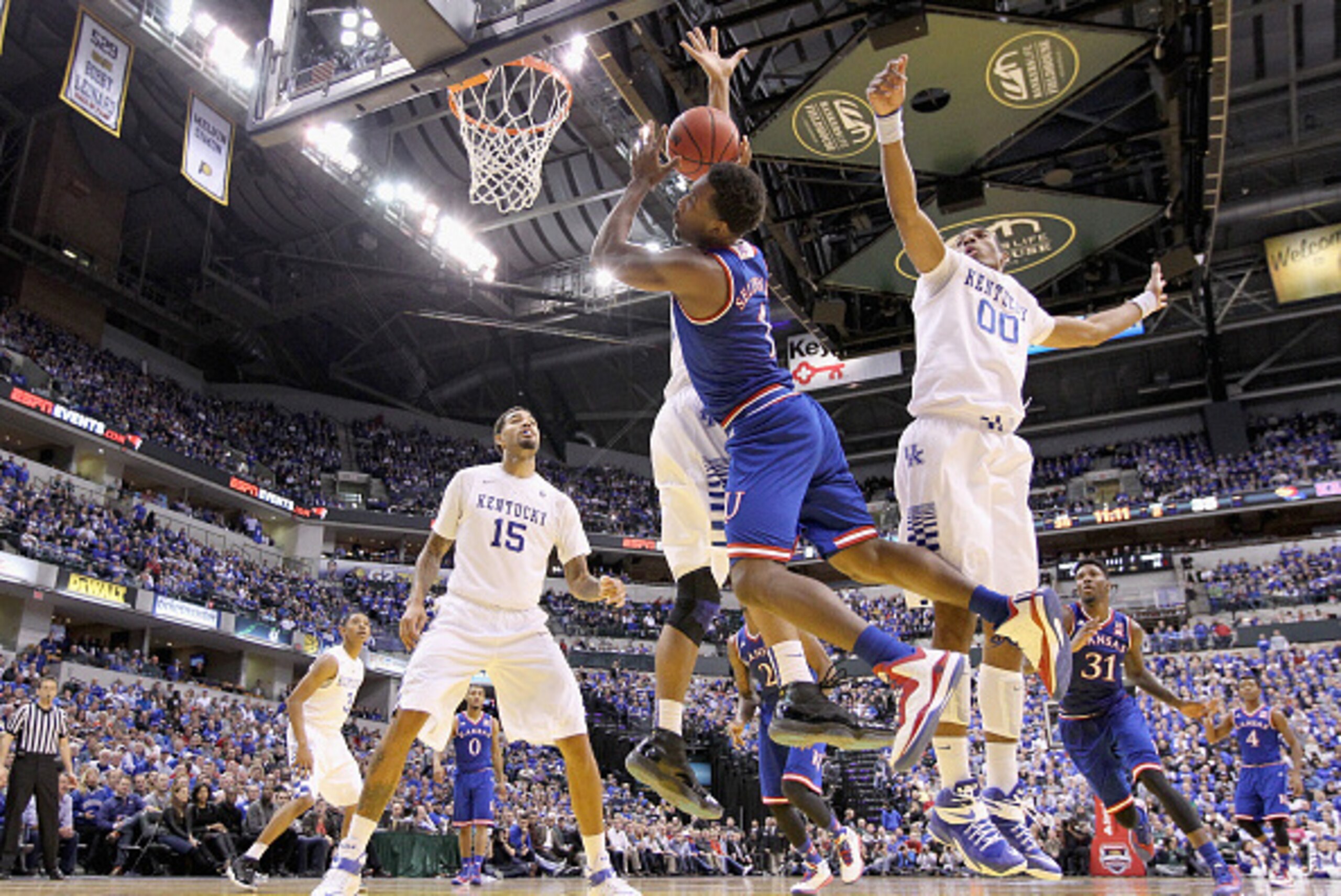 INDIANAPOLIS, IN - NOVEMBER 18: Wayne Seldon #1 of the Kansas Jayhawks loses control of the ball while defended by Trey Lyles #41 and Marcus Lee #00 of the Kentucky Wildcats in the State Farm Champions Classic at Bankers Life Fieldhouse on November 18, 2 INDIANAPOLIS, IN - NOVEMBER 18: Wayne Seldon #1 of the Kansas Jayhawks loses control of the ball while defended by Trey Lyles #41 and Marcus Lee #00 of the Kentucky Wildcats in the State Farm Champions Classic at Bankers Life Fieldhouse on November 18, 2