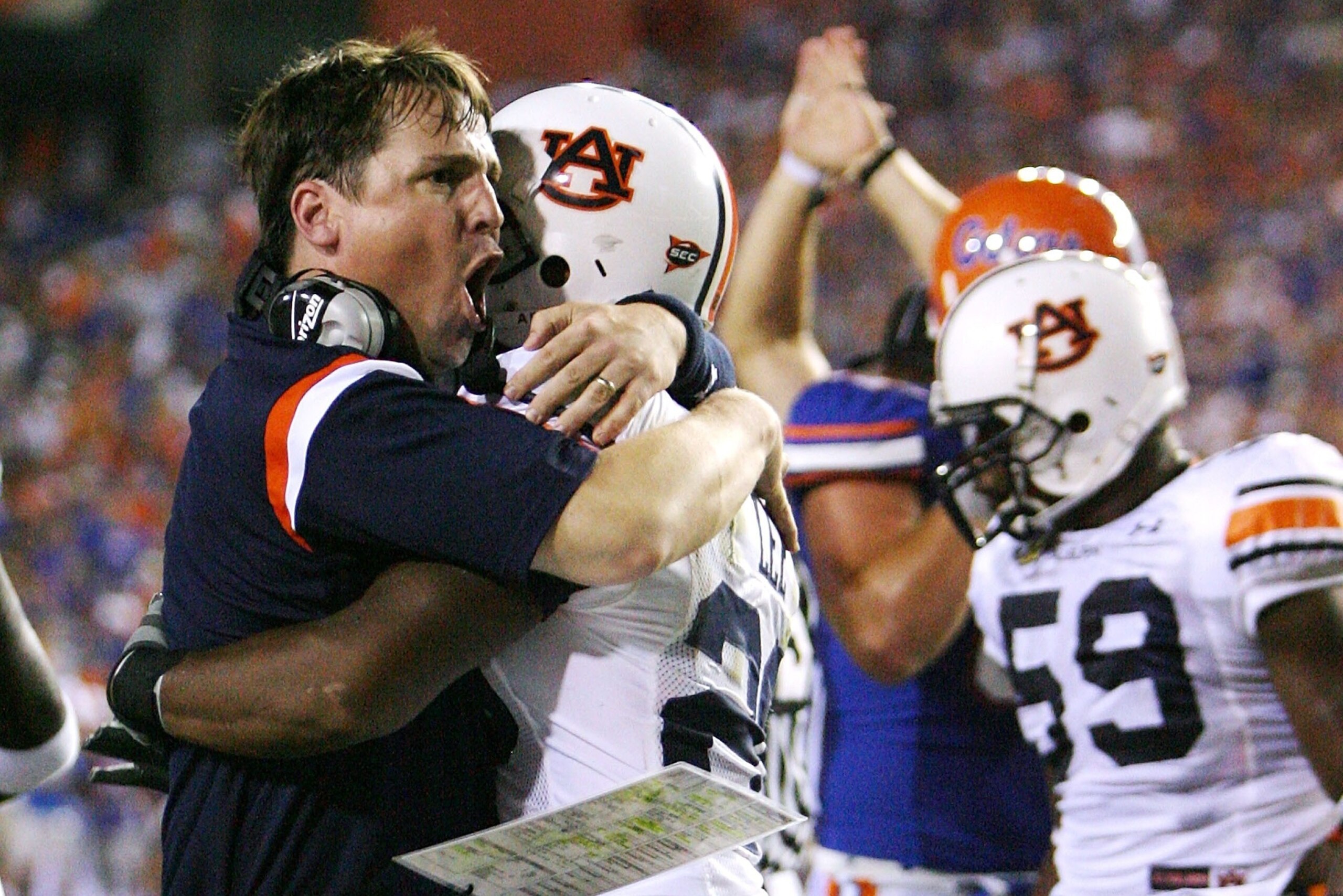 GAINESVILLE, FL - SEPTEMBER 29:  Defensive coordinator Will Muschamp of the Auburn Tigers jumps into the arms of defensive back Patrick Lee #20 after Lee helped cause a fumble late in the first half against the Florida Gators at Ben Hill Griffin Stadium S