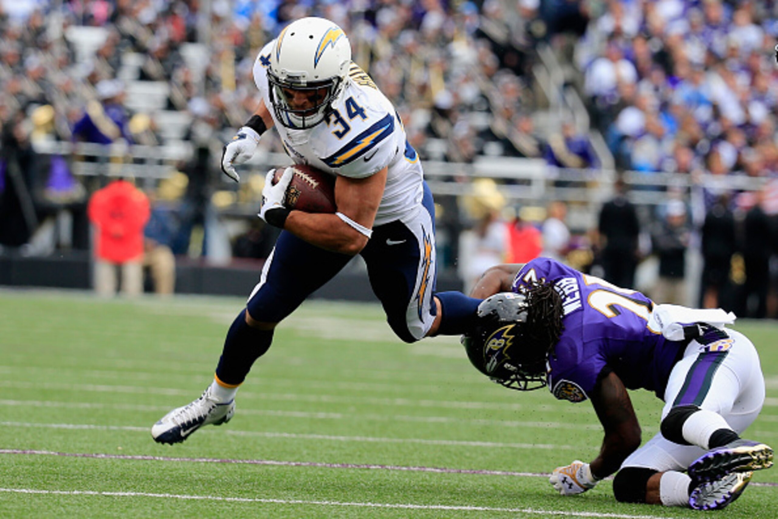 BALTIMORE, MD - NOVEMBER 30: Running back Donald Brown #34 of the San Diego Chargers is tackled by cornerback Lardarius Webb #21 of the Baltimore Ravens in the first quarter of a game at M&T Bank Stadium on November 30, 2014 in Baltimore, Maryland.  (Phot