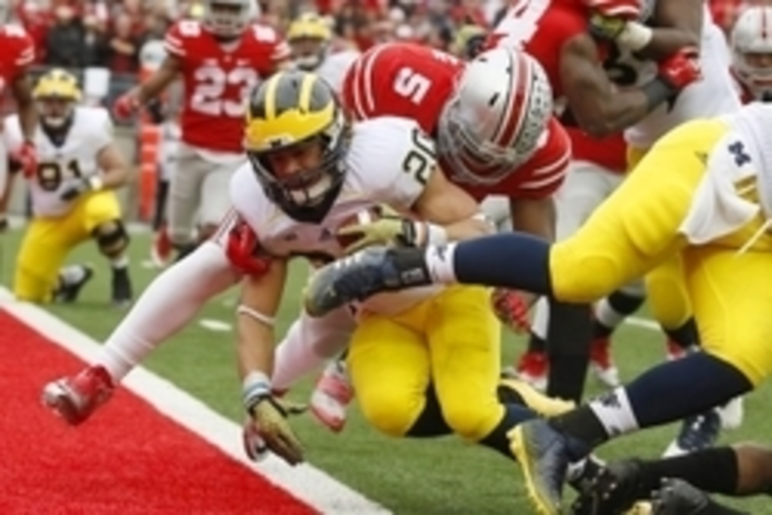 Nov 29, 2014; Columbus, OH, USA; Michigan Wolverines running back Drake Johnson (20) plunges in for the touchdown past Ohio State Buckeyes linebacker Raekwon McMillan (5) during third quarter action at Ohio Stadium. Ohio State won the game 42-28. Mandator